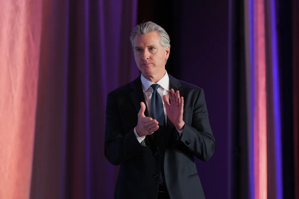 Gov. Gavin Newsom claps at the National Association of Latino Elected and Appointed Officials conference.
