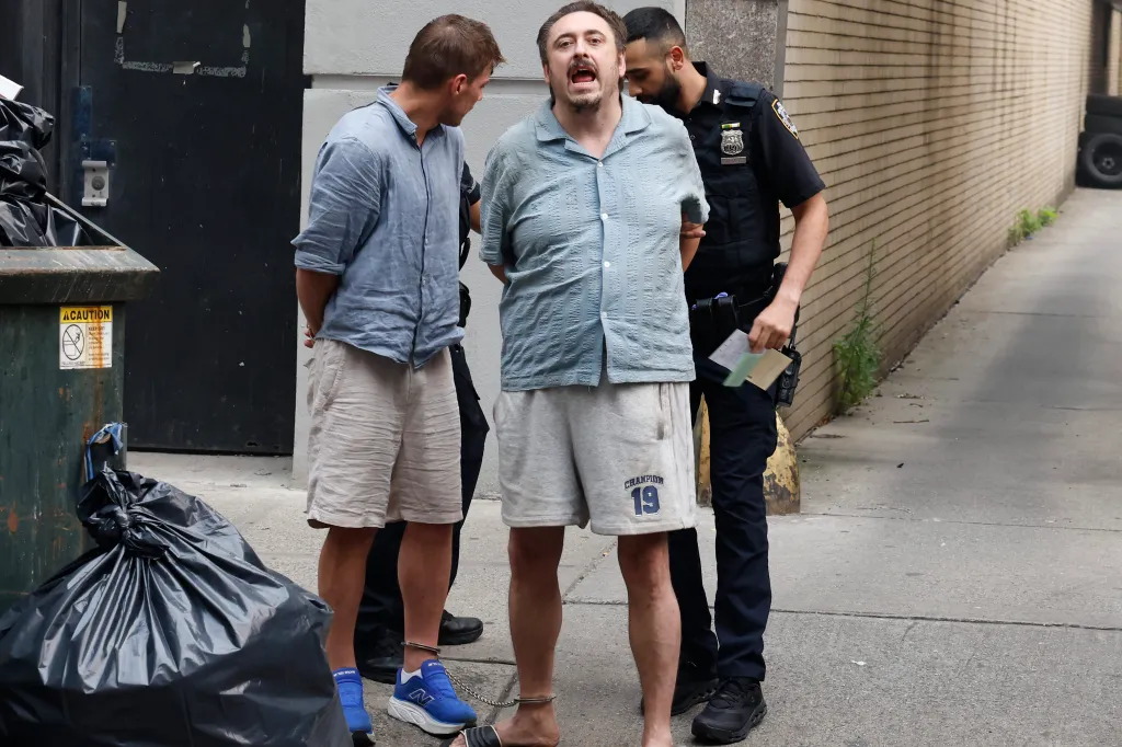Andrew Truelove, handcuffed and shackled at the ankles, being escorted by police.