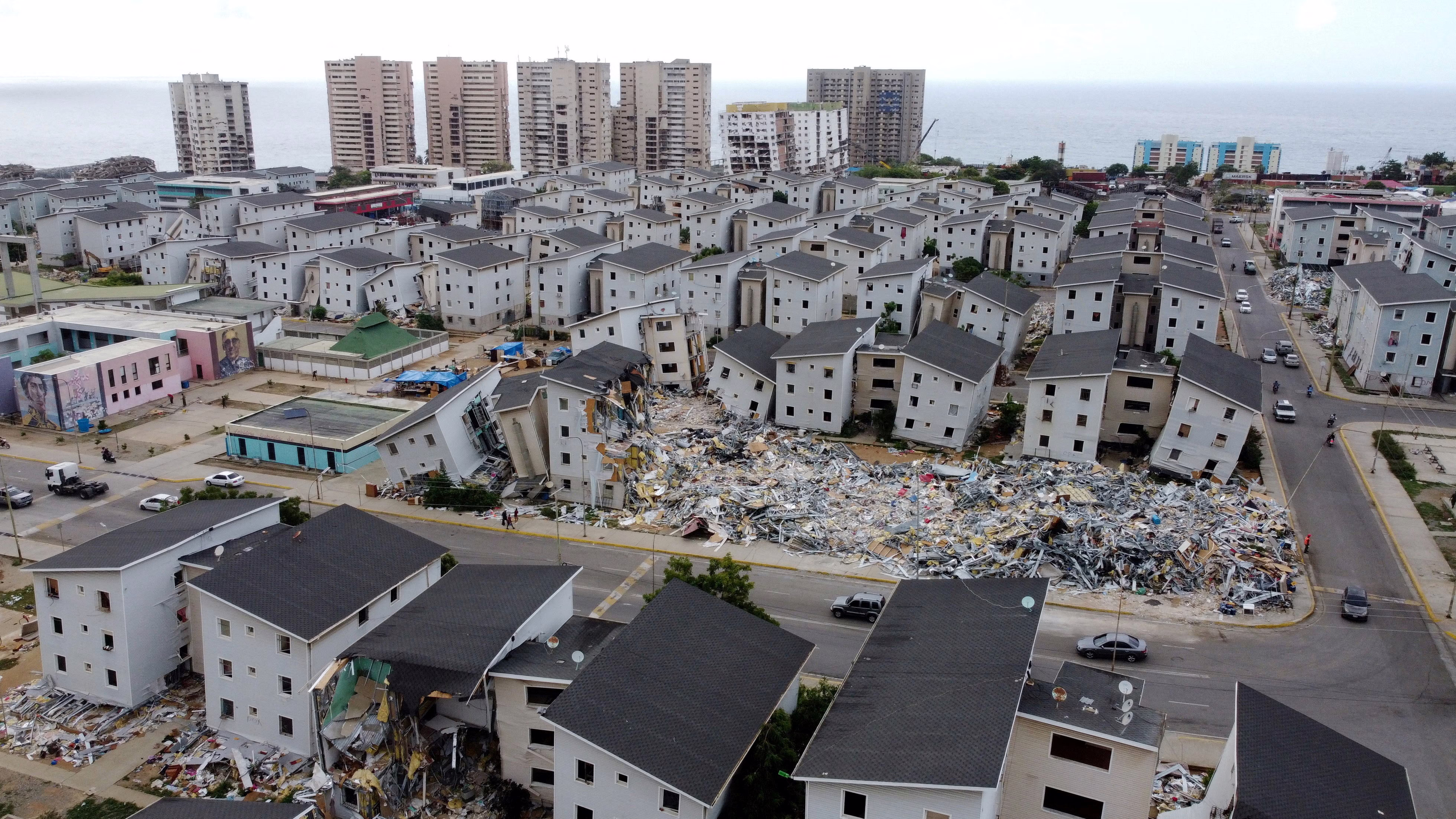 A mix of damaged, collapsed, and partially-damaged residential buildings, seen weeks after an earthquake