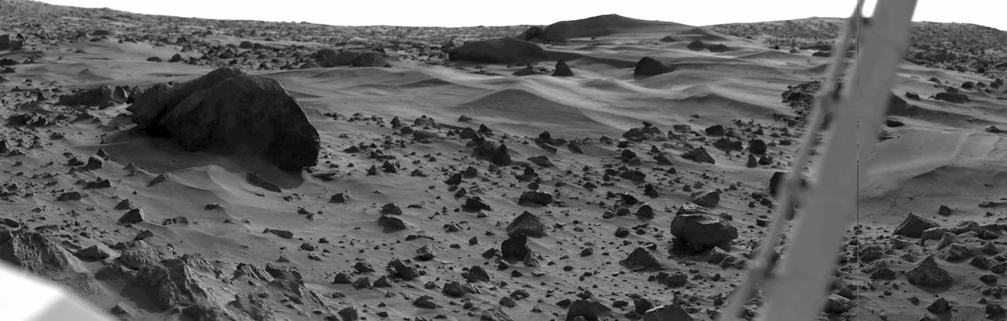 A black-and-white image of the sandy and rocky surface of Mars