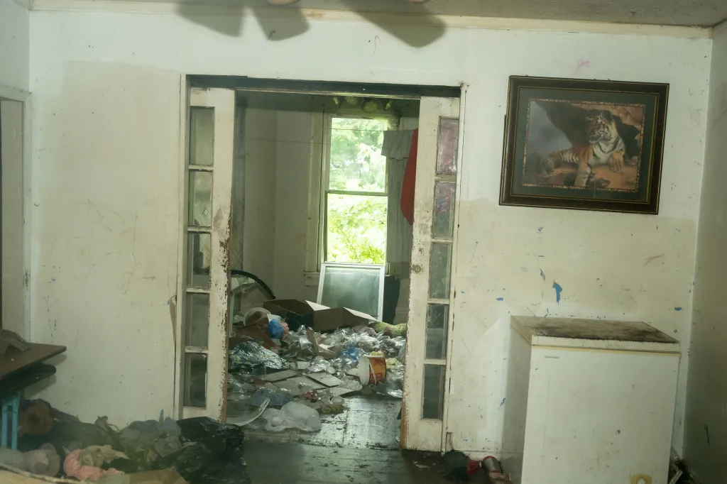 Interior view of the Sider’s home with trash and debris covering the floor.