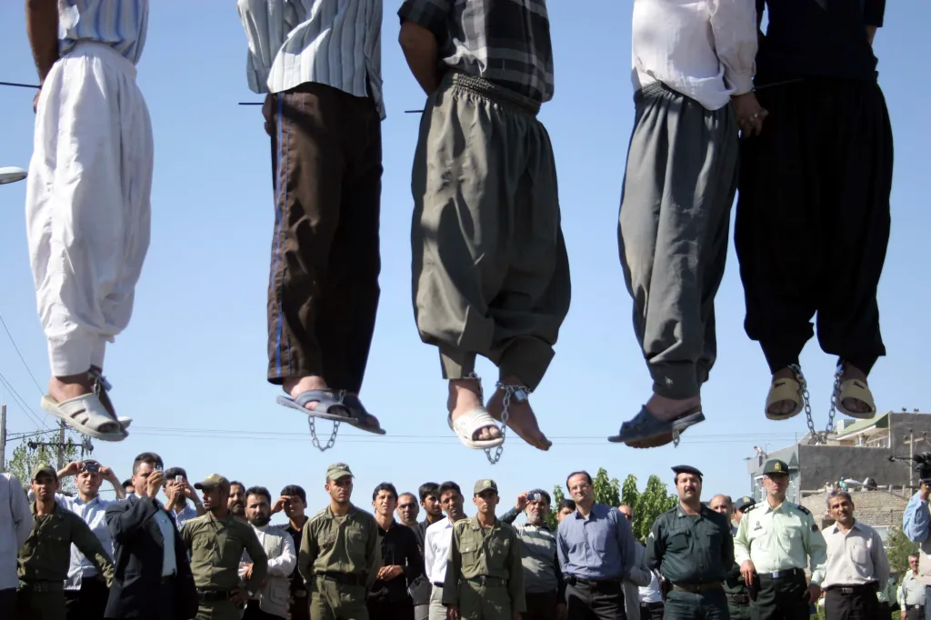 Iranian police officers and others view the scene as five convicted criminals are hanged in a neighborhood of Mashad, 1620 miles northwest of Tehran, Iran on Aug. 1, 2007.