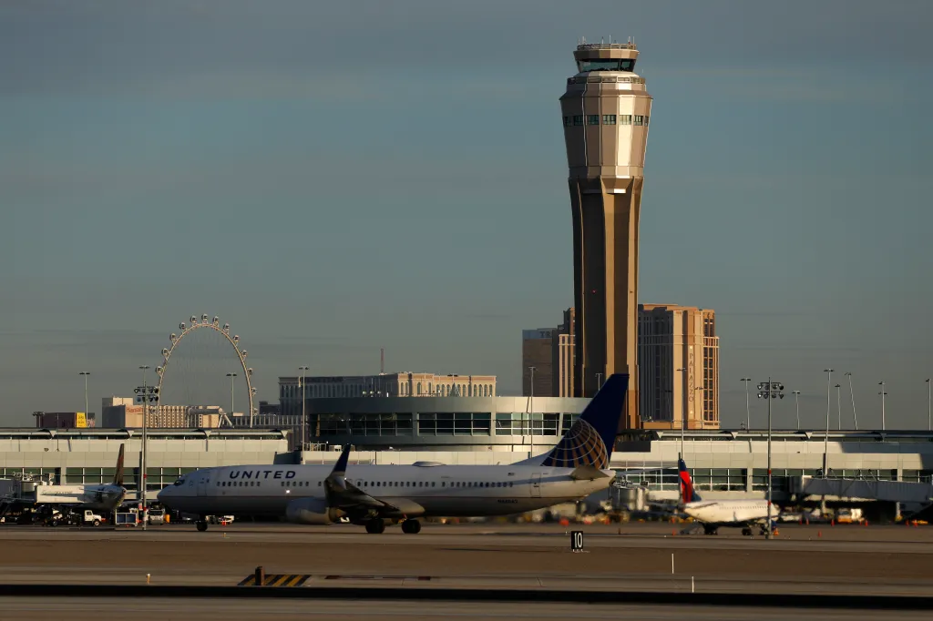 A United Airlines plane on the tarmac with an airport control tower in the background, Las Vegas, Nevada.