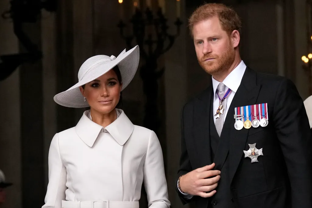 Prince Harry, in a black suit with medals, and Meghan Markle , in a white hat and white coat, leave St Paul's Cathedral in London.