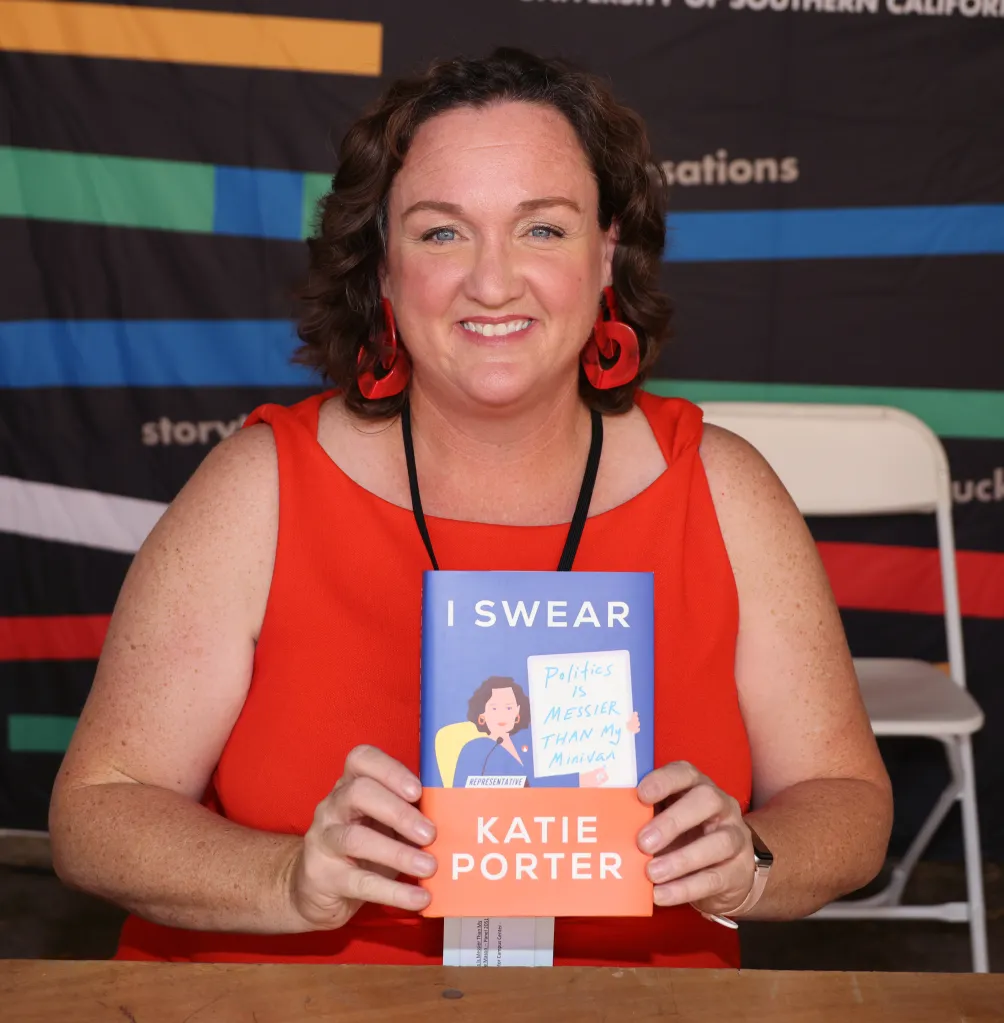 Katie Porter holds up her book, 