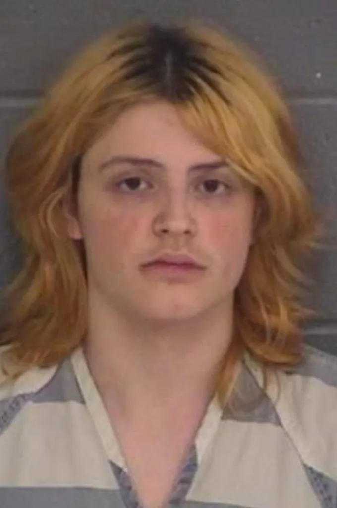 Mugshot of Colt Gray, a young white male with shoulder-length blonde hair and a light mustache, wearing a striped shirt.