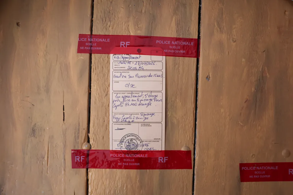 French police seals and official paperwork on a door from an investigation in Orange, southern France.