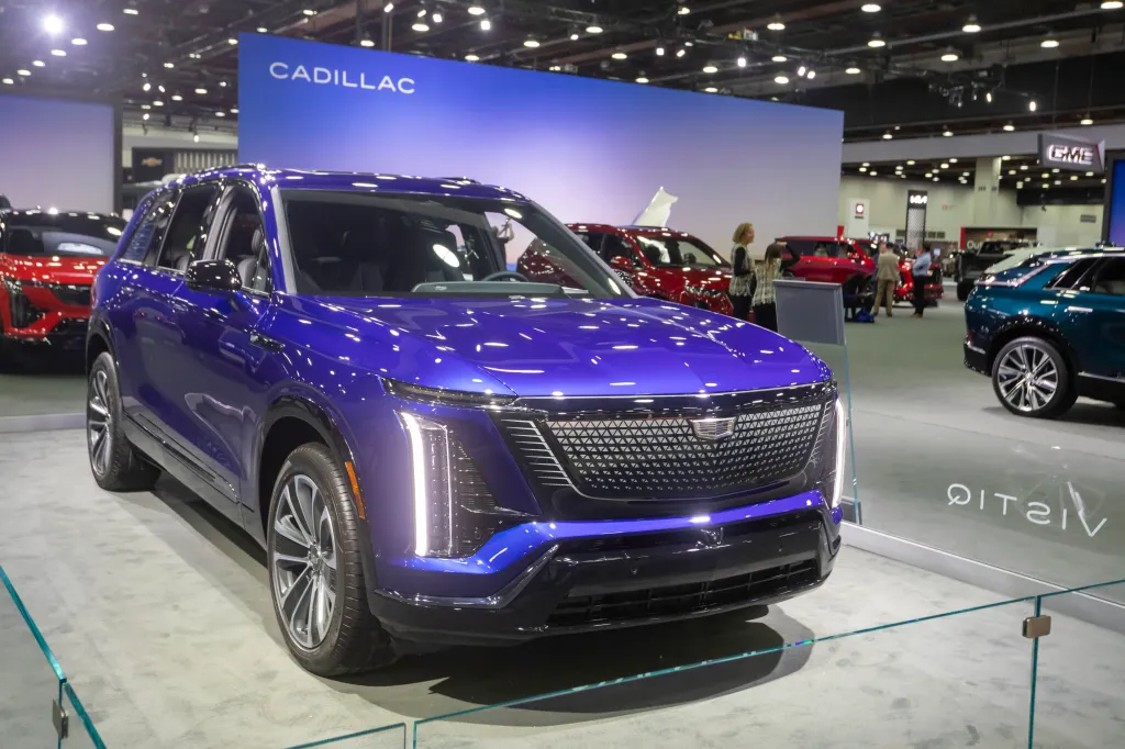 The 2026 Cadillac Vistiq in a vibrant blue color is displayed at the 2025 Detroit Auto Show.