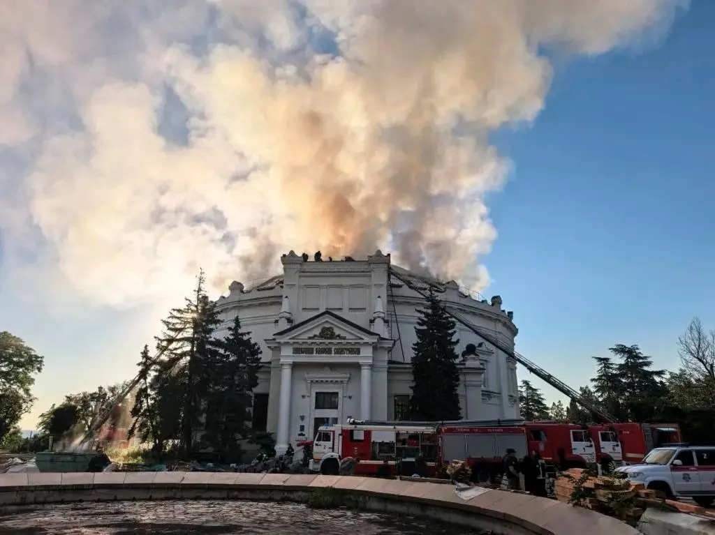 Firefighters battle a fire on the roof of the 