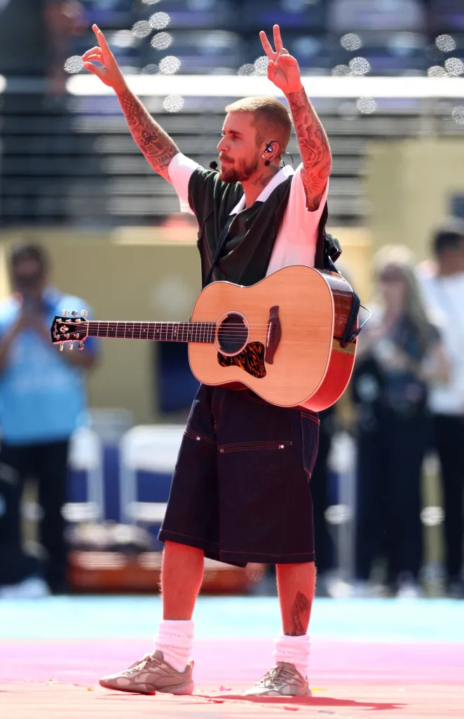 Justin Bieber performing during the halftime show, holding an acoustic guitar.