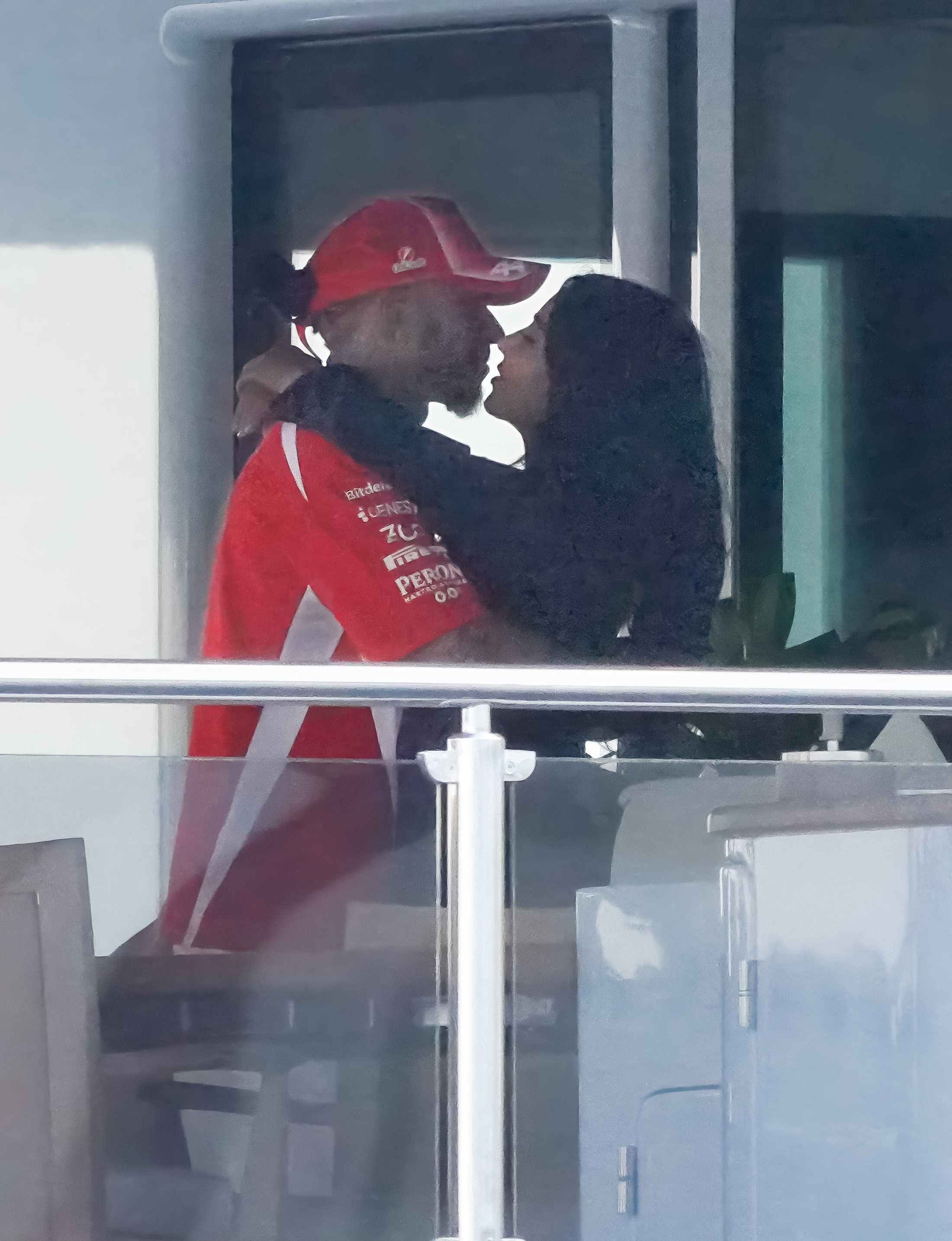 Kim Kardashian embracing Lewis Hamilton, both wearing dark tops, on a yacht.