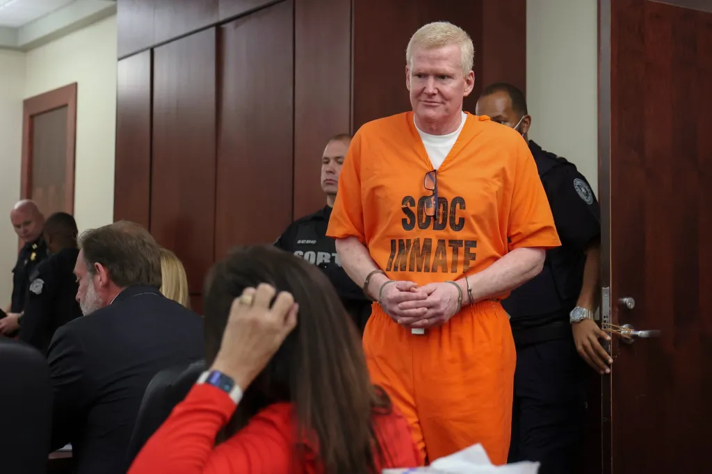 Alex Murdaugh arrives for a judicial hearing in an orange inmate jumpsuit with handcuffs.