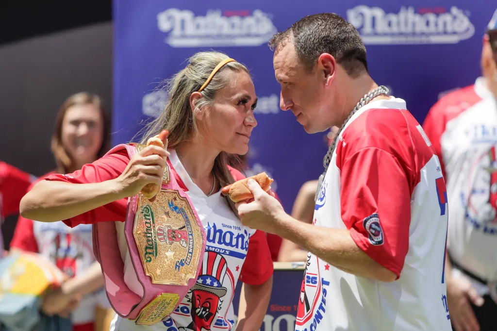 Competitive eaters Michelle Lesco and Nick Wehry hold hot dogs and face each other during the weigh-in for the Nathan's Famous Fourth of July International Hot Dog Eating Contest.
