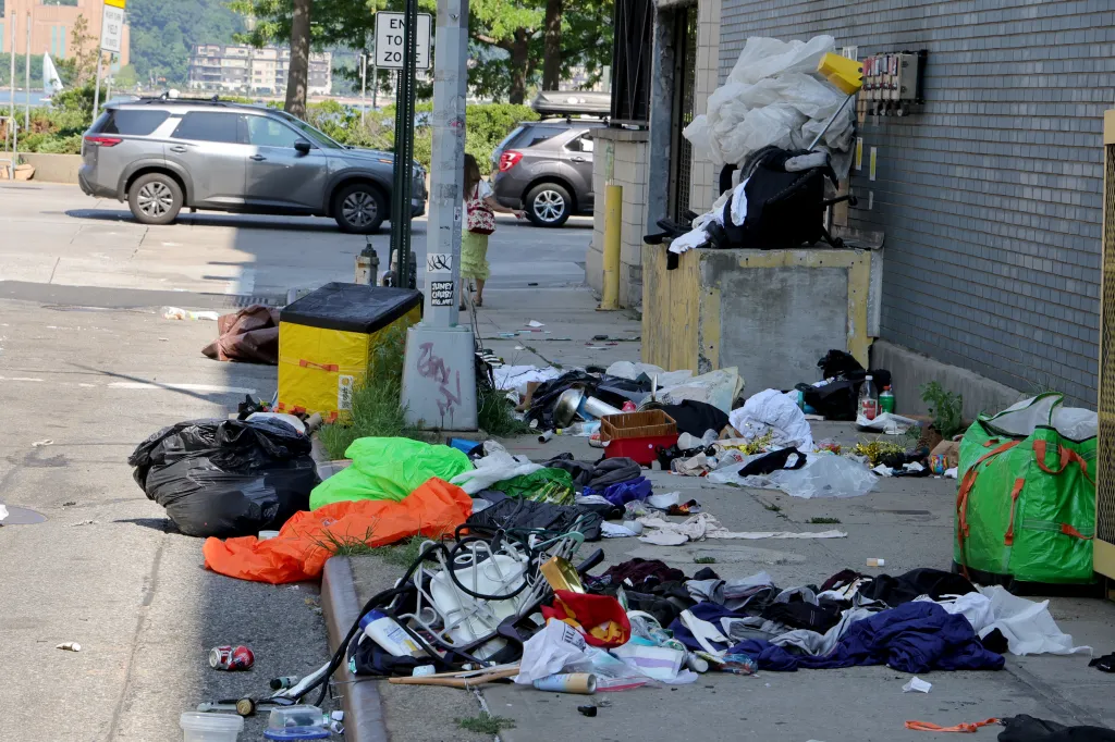 Trash and personal belongings clutter a sidewalk in Midtown Manhattan.