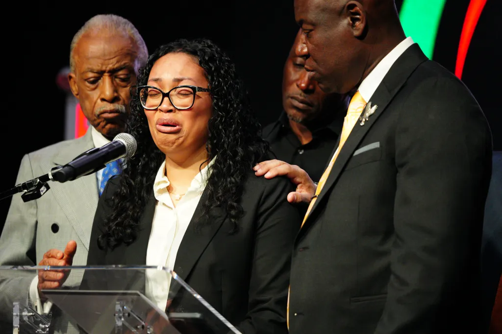 Christine Wonsley, Nolan Wells' mother, cries while standing at a podium with Rev. Al Sharpton and civil rights attorney Ben Crump.