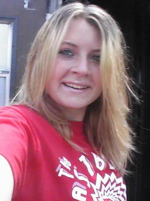Elizabeth Siders, with blonde hair and a red shirt, smiles.