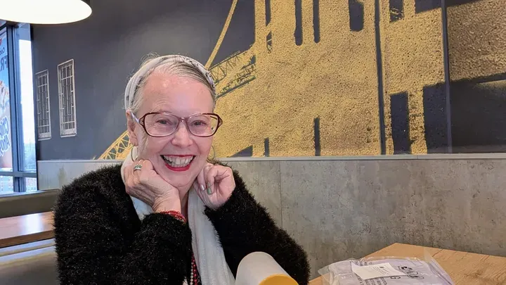Rachell Summers, the 73-year-old Capitola artist, smiles as she rests her chin on her hand.