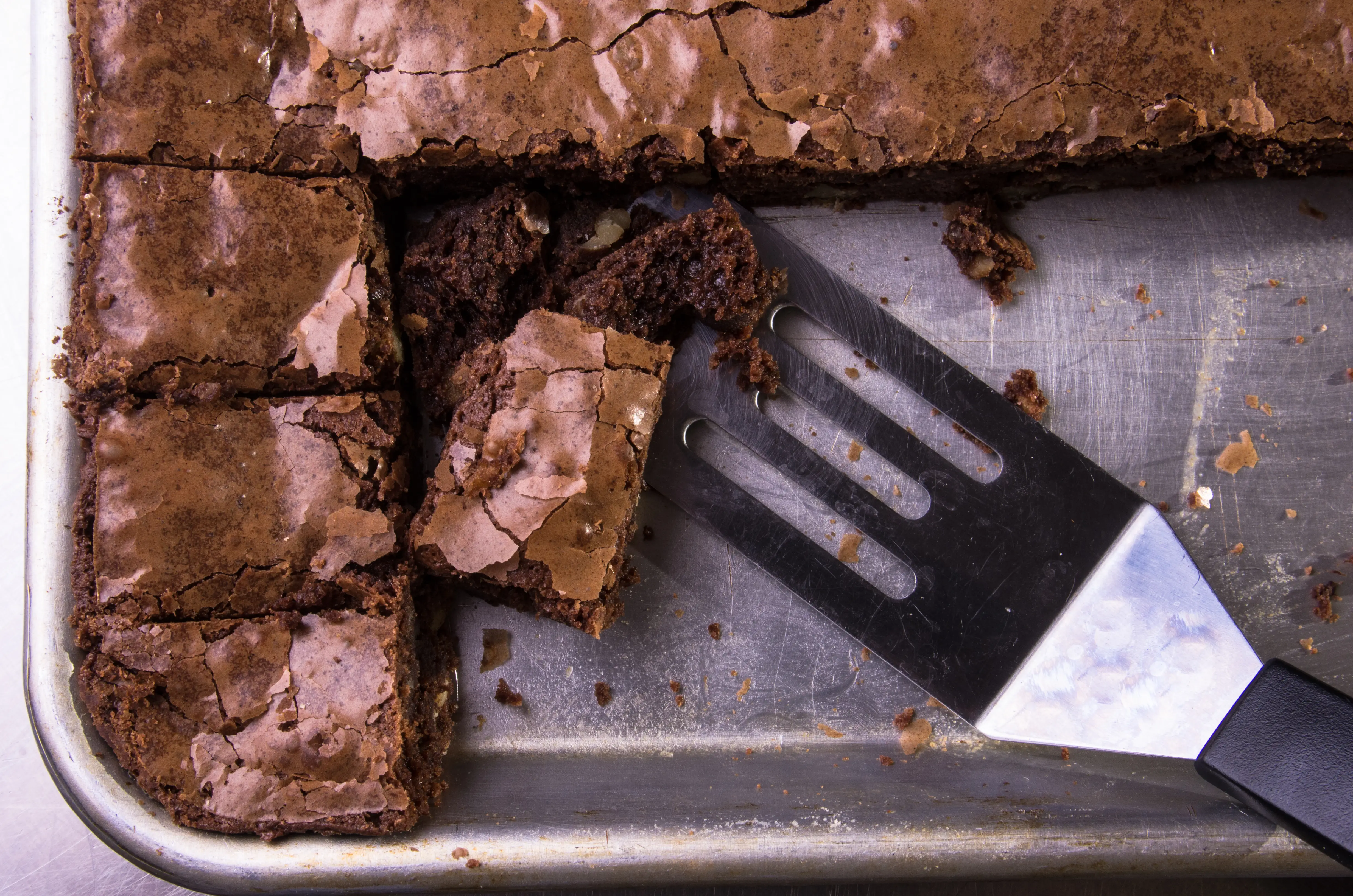 A tray of brownies with a spatula scooping one out