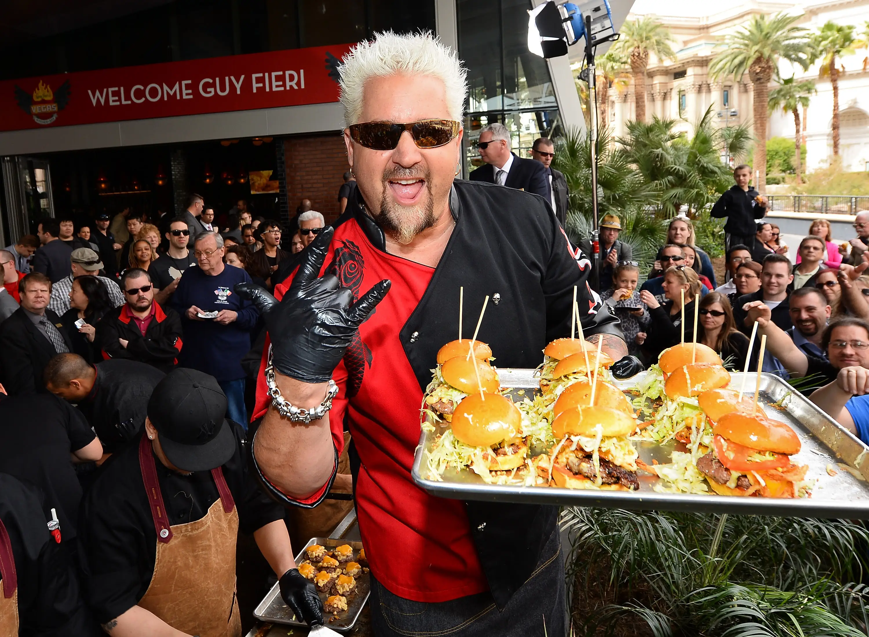 guy fieri holding hamburgers on a tray