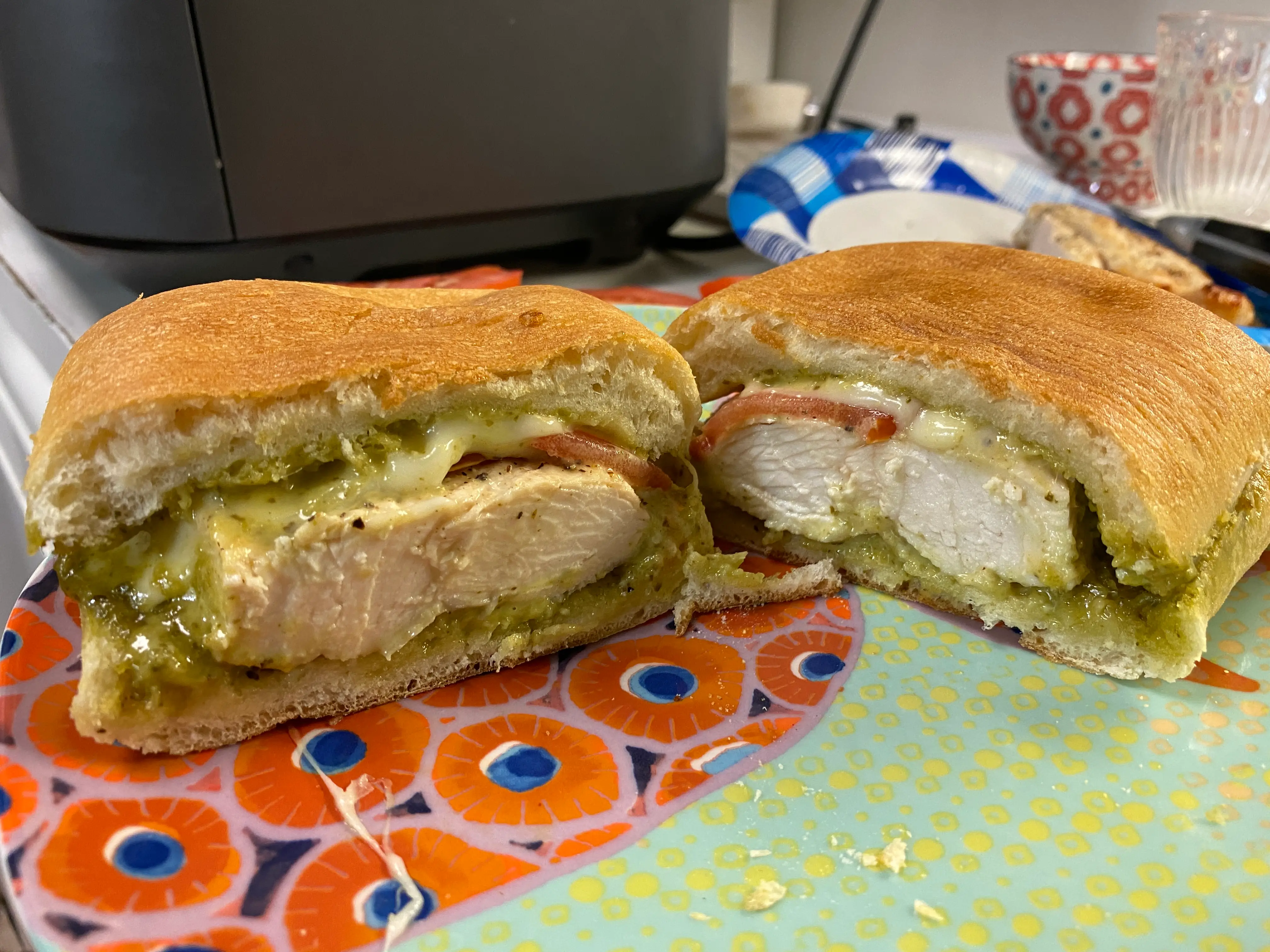 chicken, pesto-mayo and tomato on a sandwich that's cut in half