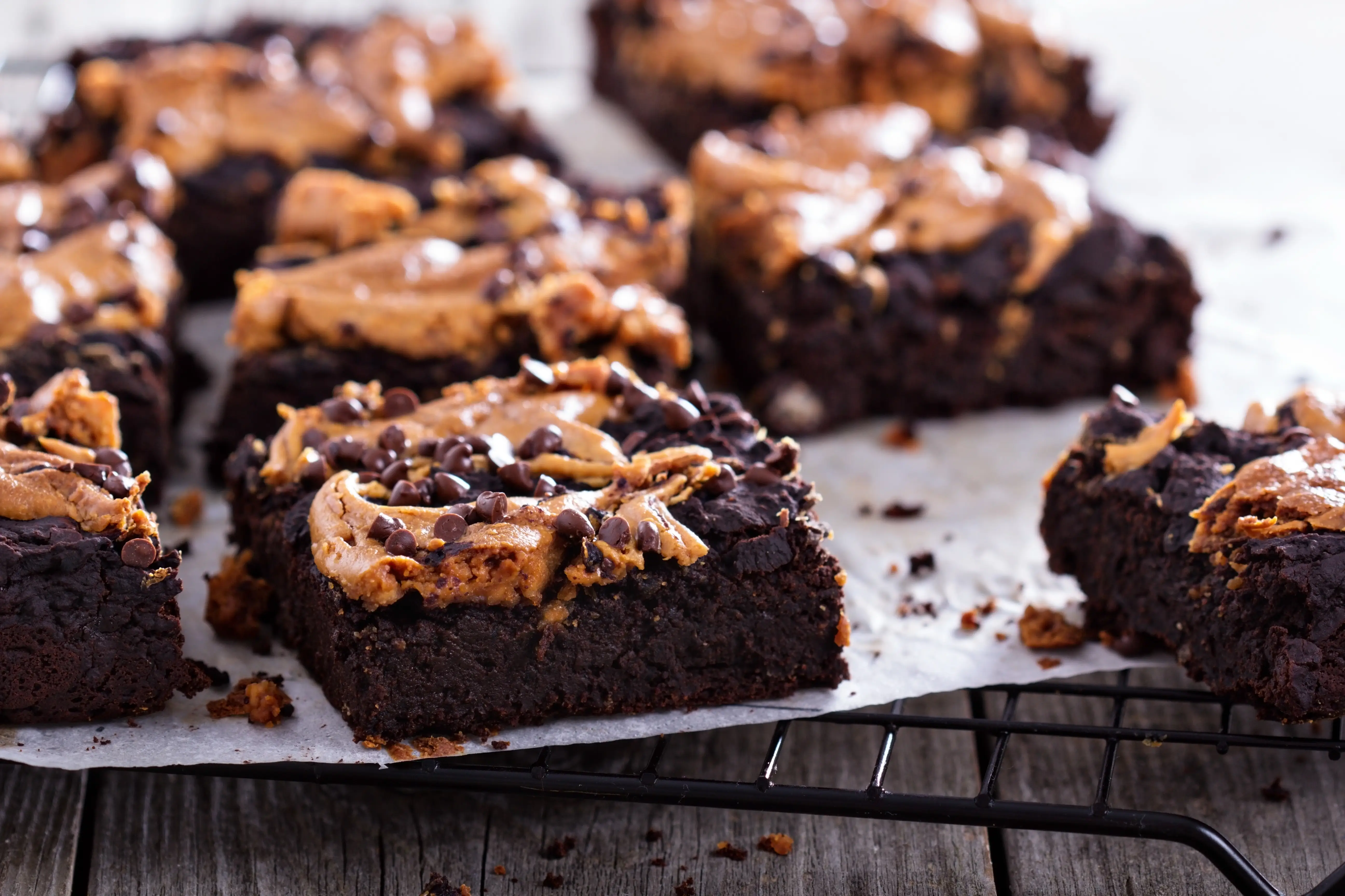 brownies topped with peanut butter and chocolate chips on a cooling rack