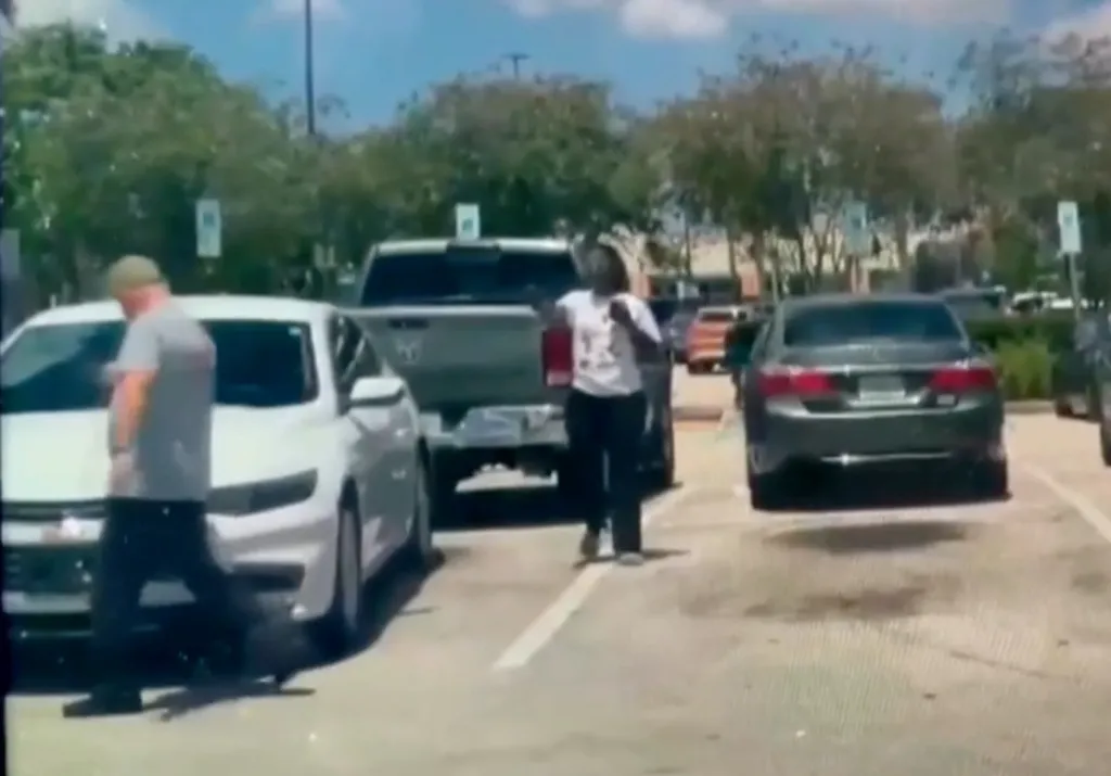 Diguglielmo appears to follow the woman around another car as she aims the gun at him before a single gunshot rings out and he collapses to the ground.