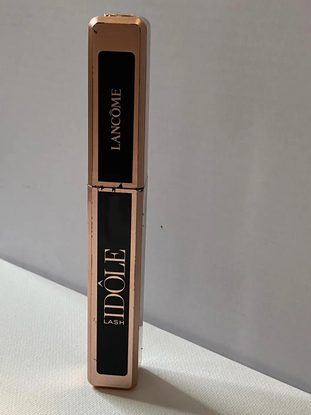 A gold and black tube of mascara with gold text that says 