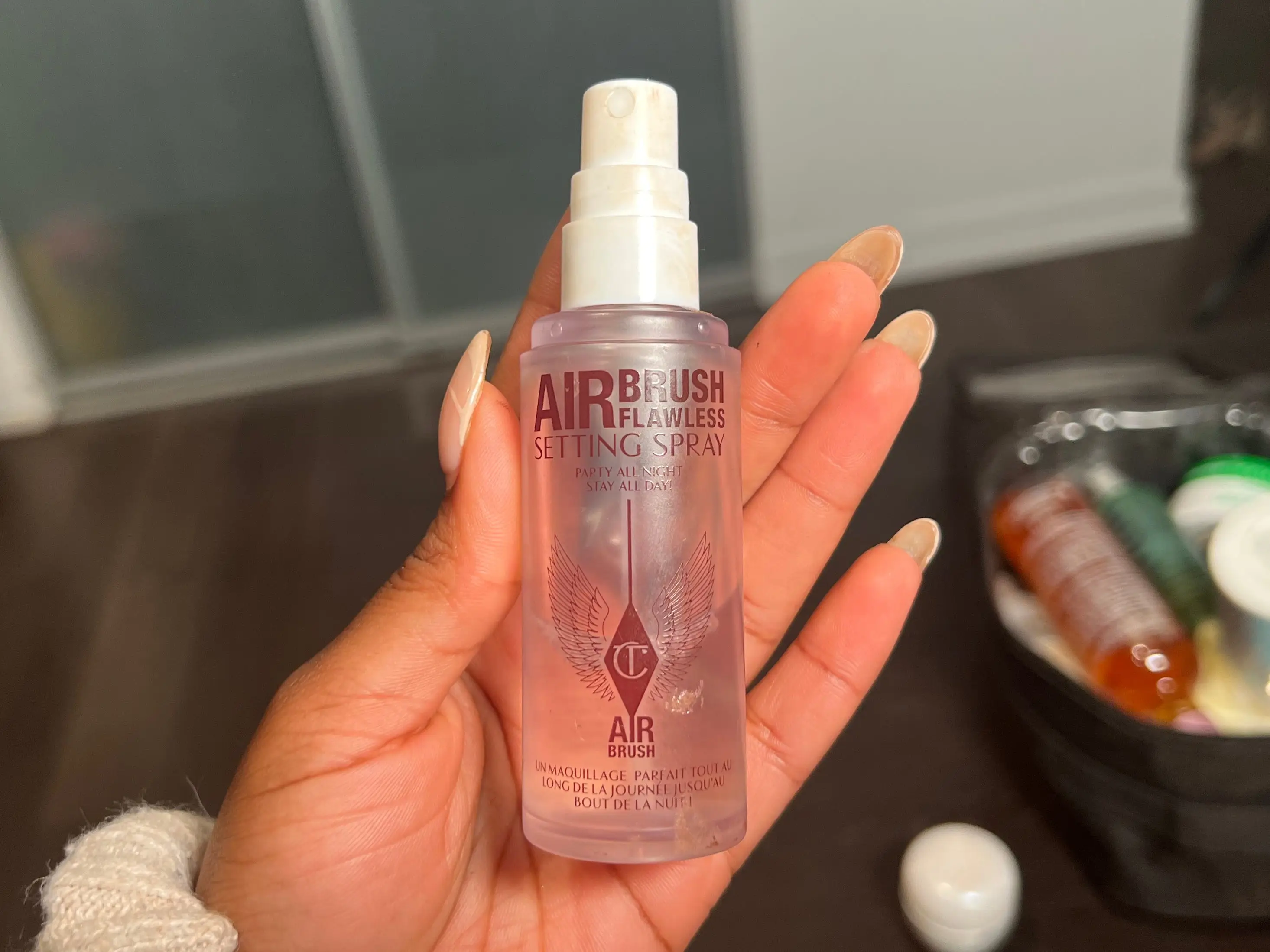The writer holds a clear bottle with red text and a white spray and cap