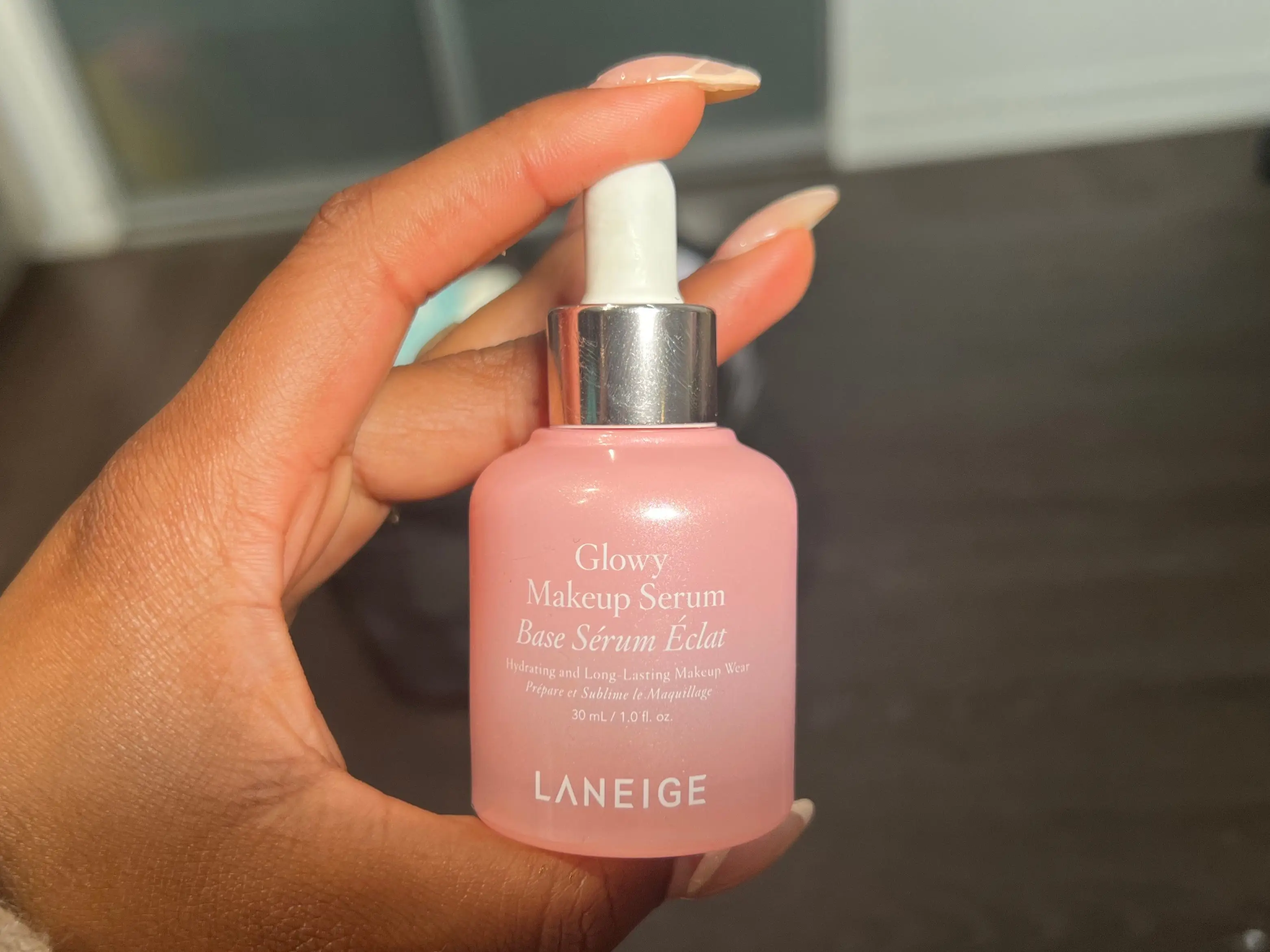 The writer holds a pink bottle with white