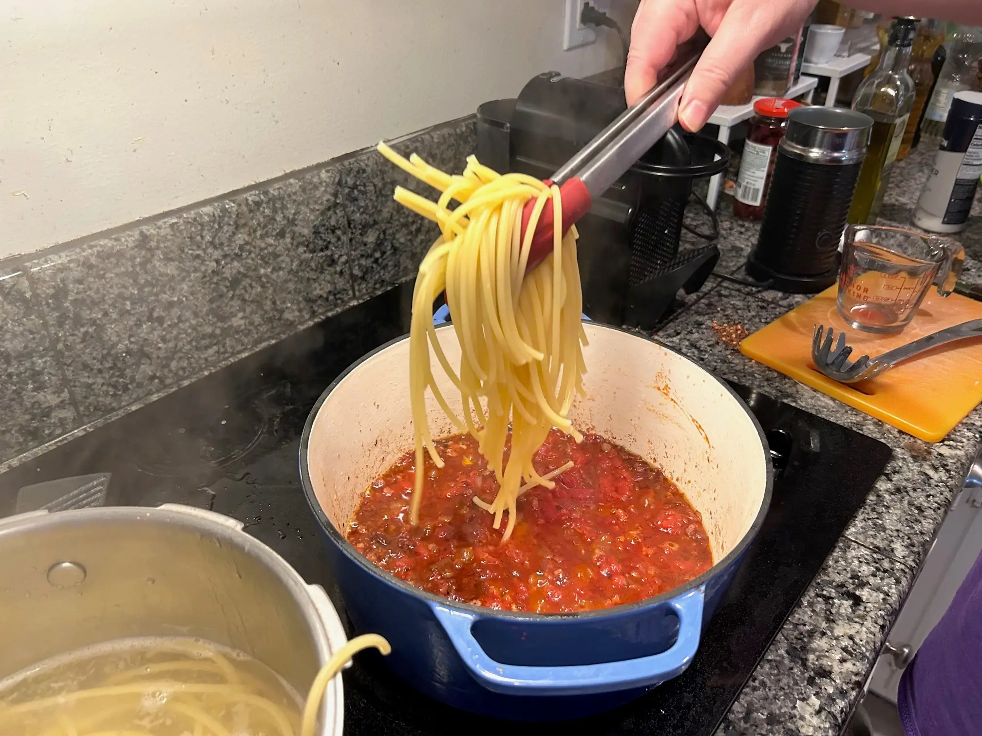 Adding the pasta to the sauce for Ina Garten's weeknight pasta