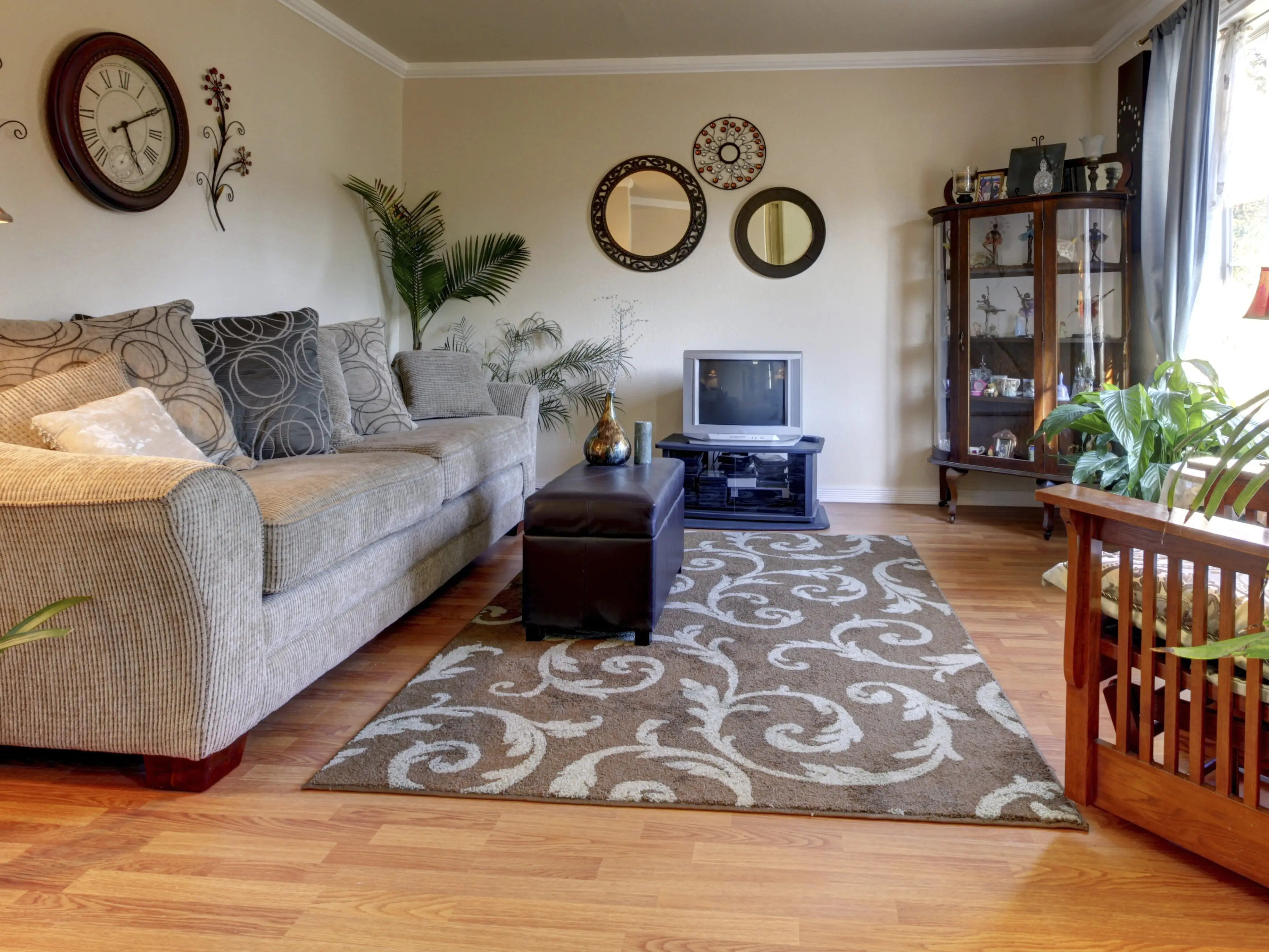 A living room with a rug in the center of the room with a coffee table on top of it
