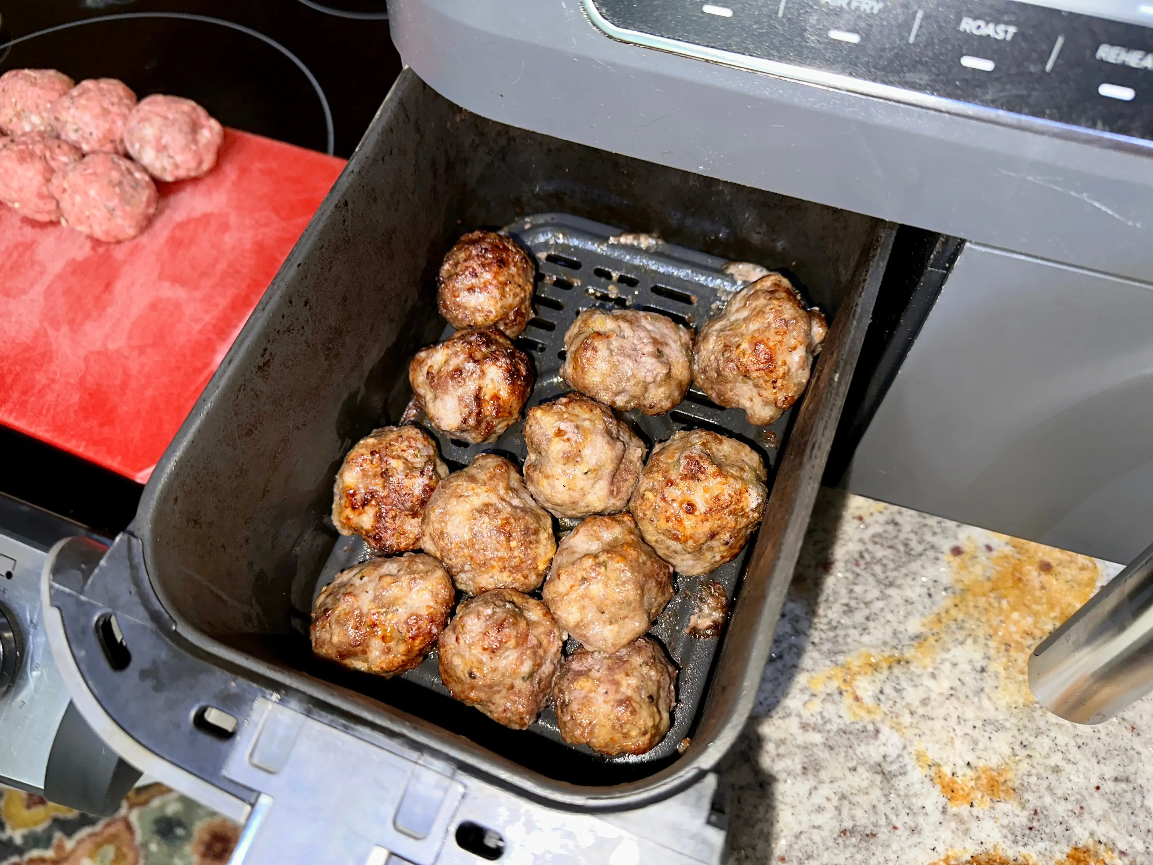 Meatballs in an air-fryer basket.