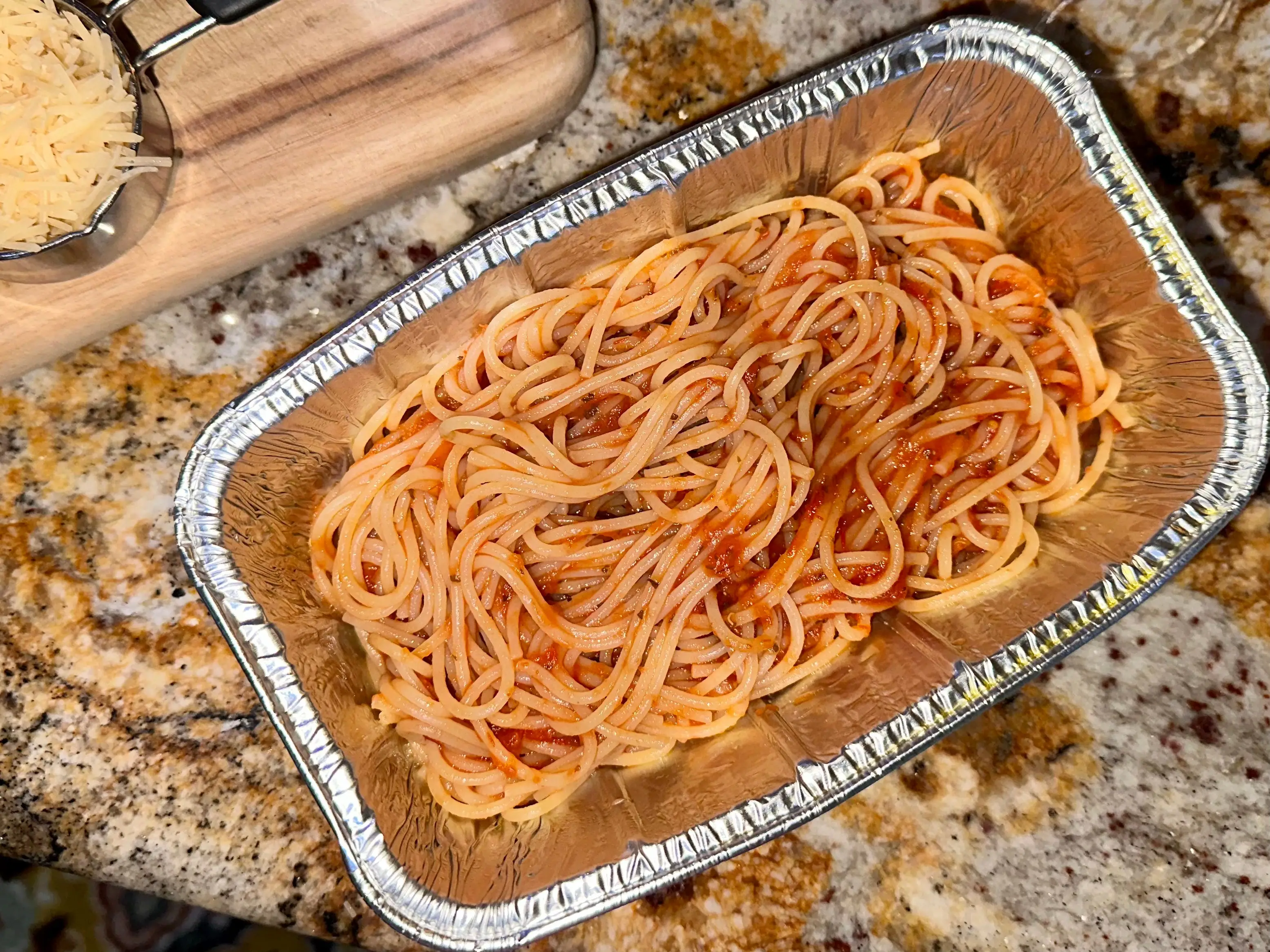 Spaghetti and sauce in a foil pan.