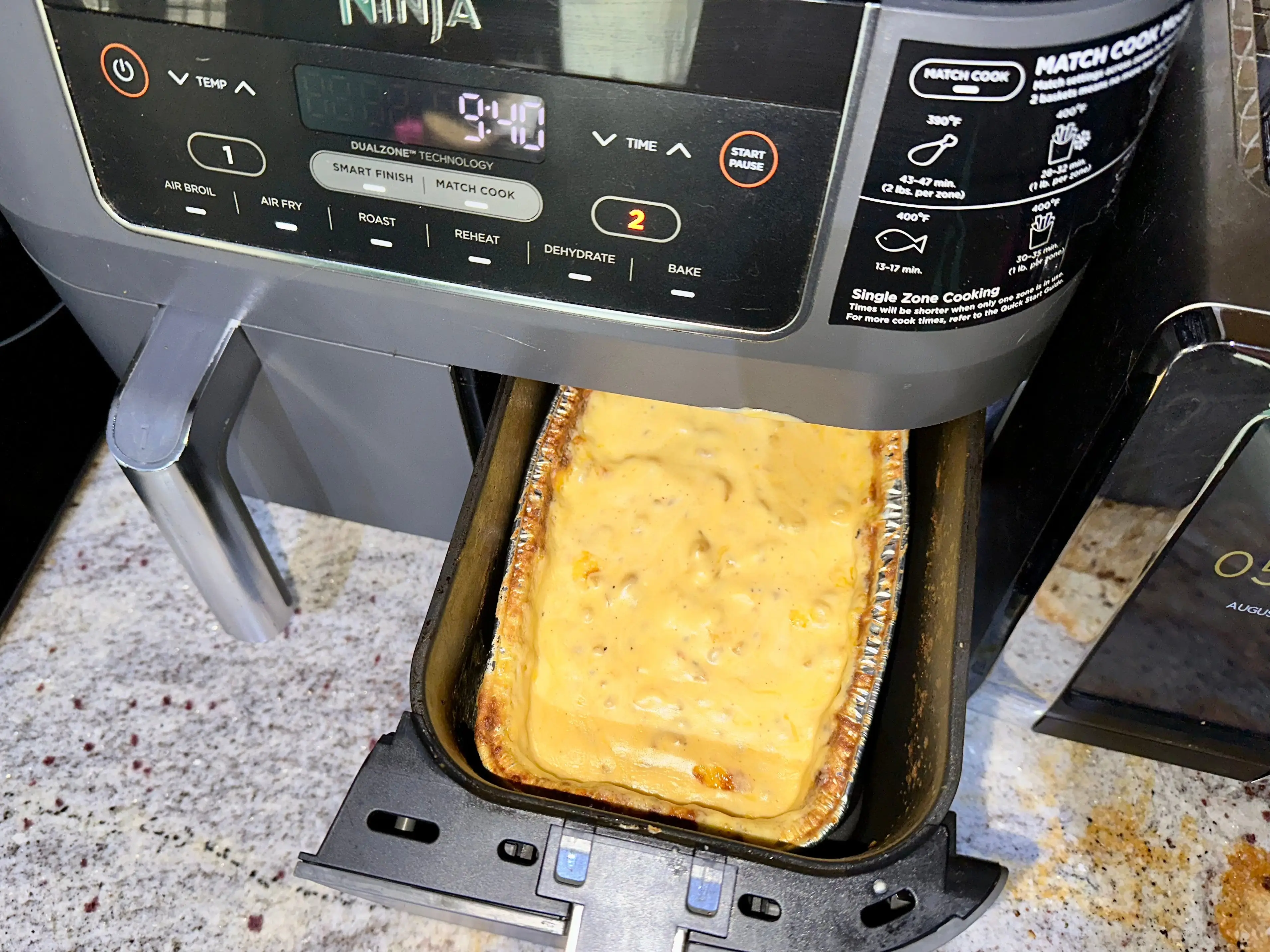 Mac and cheese in a foil dish inside of an air fryer.