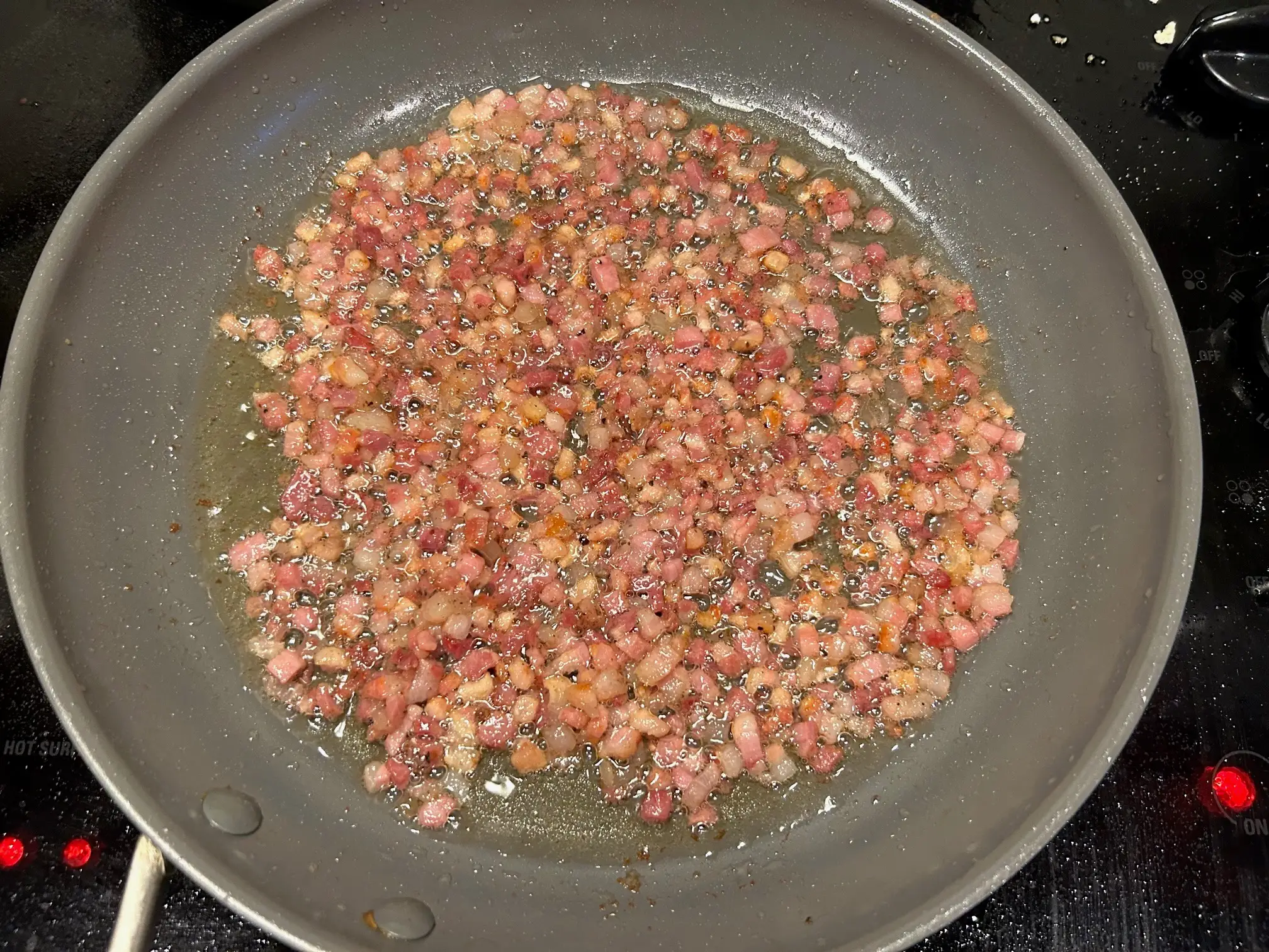 Adding the pancetta to a pan for Giada De Laurentiis' Bucatini All'Amatriciana pasta