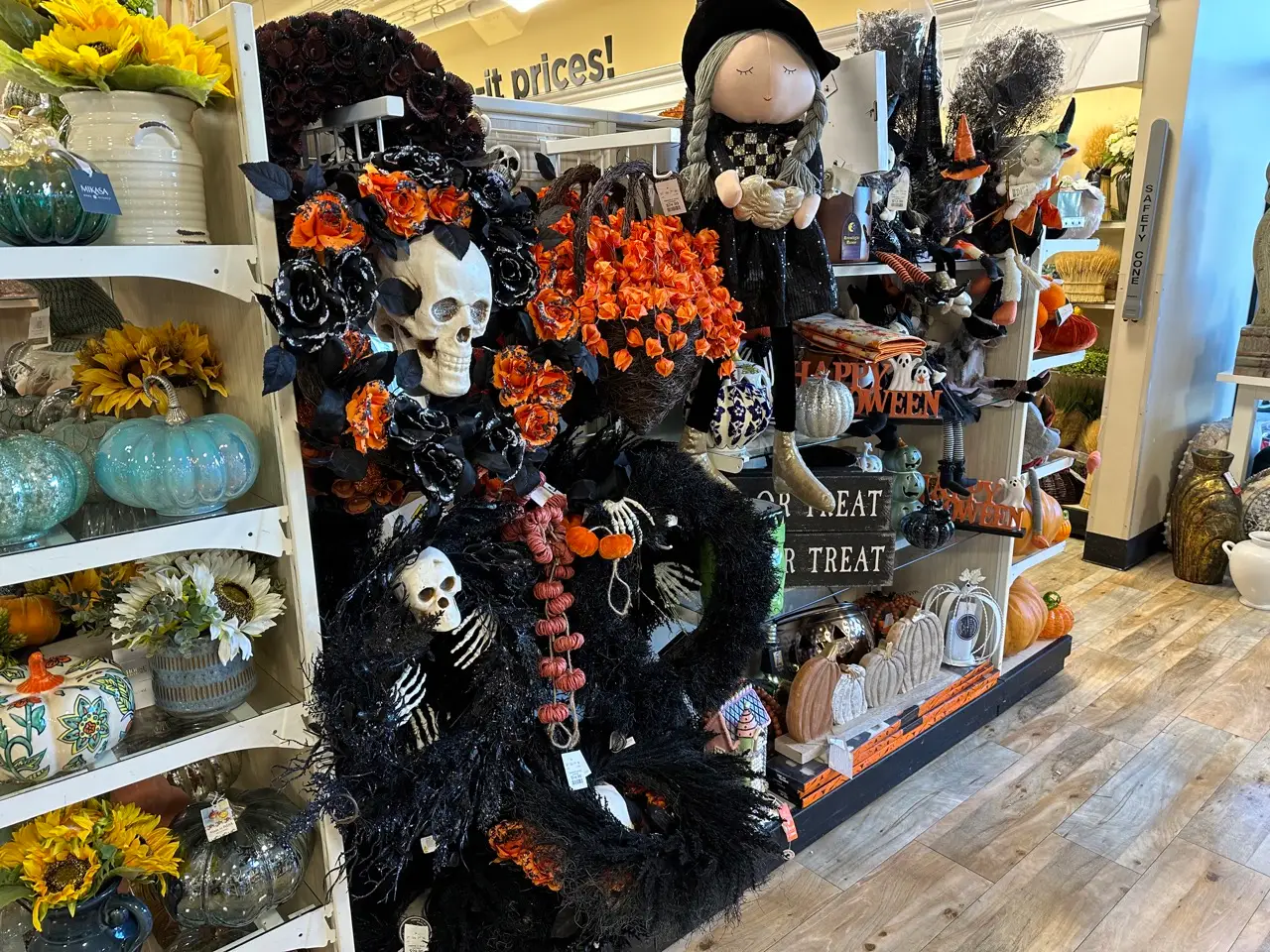Halloween wreaths and black and orange florals on display in a Homegoods aisle