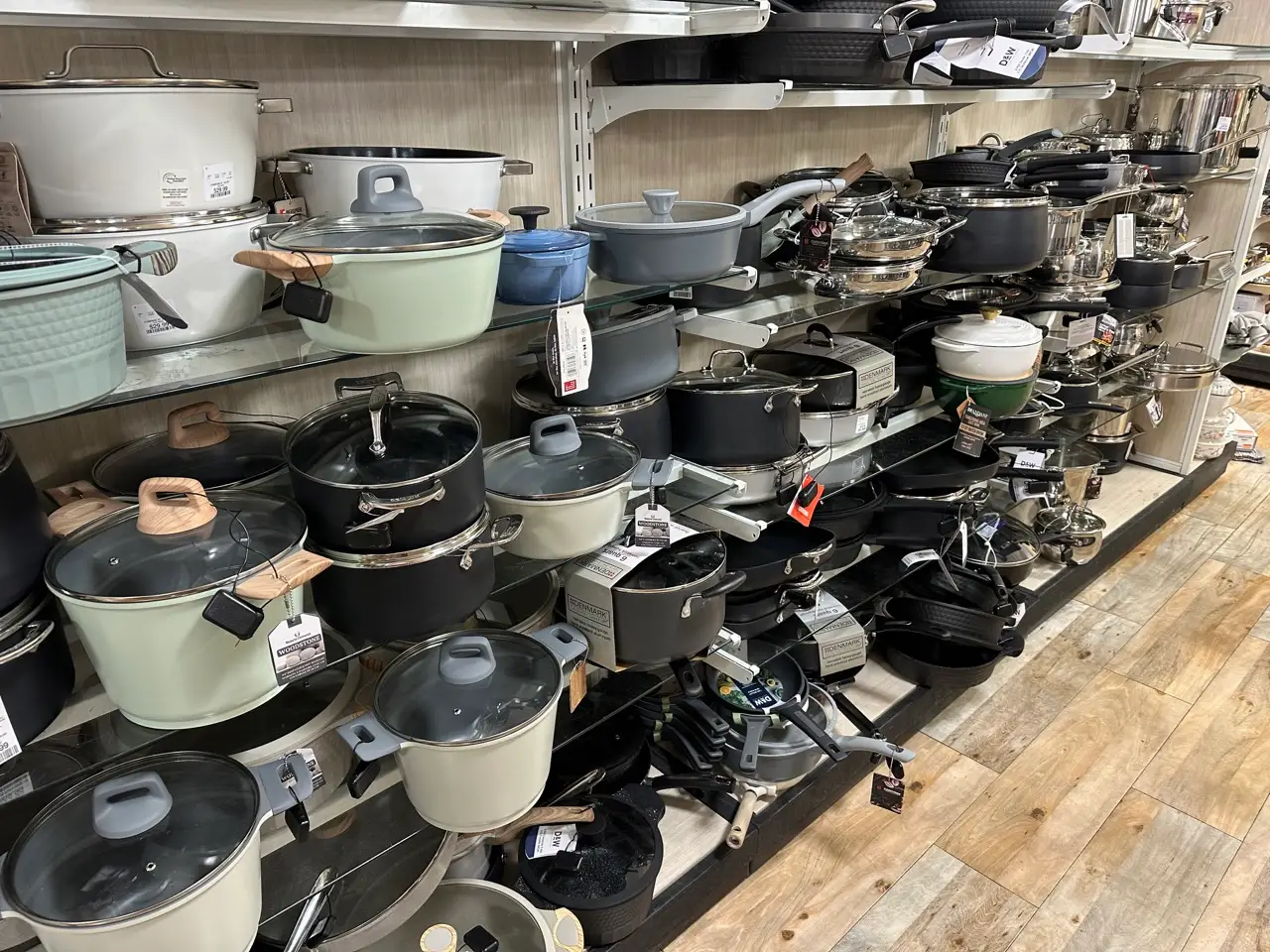 Aisle in Homegoods with glass shelves stacked with a range of pots