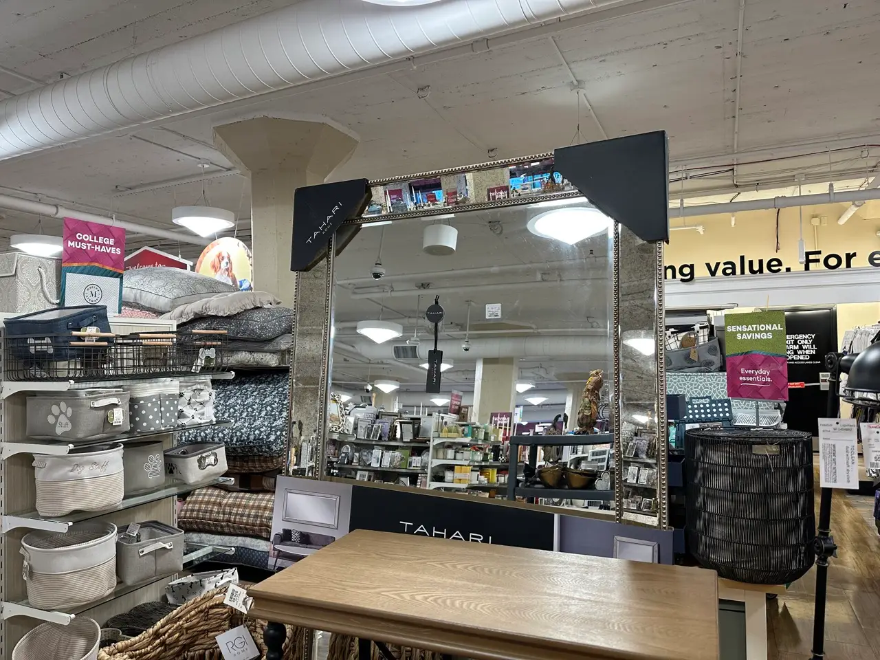 A large mirror in a HomeGoods store with a silver border