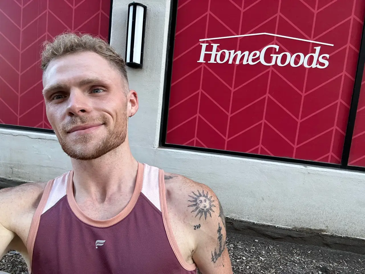 Author Paynter Rhed smiling in front of a HomeGoods sign