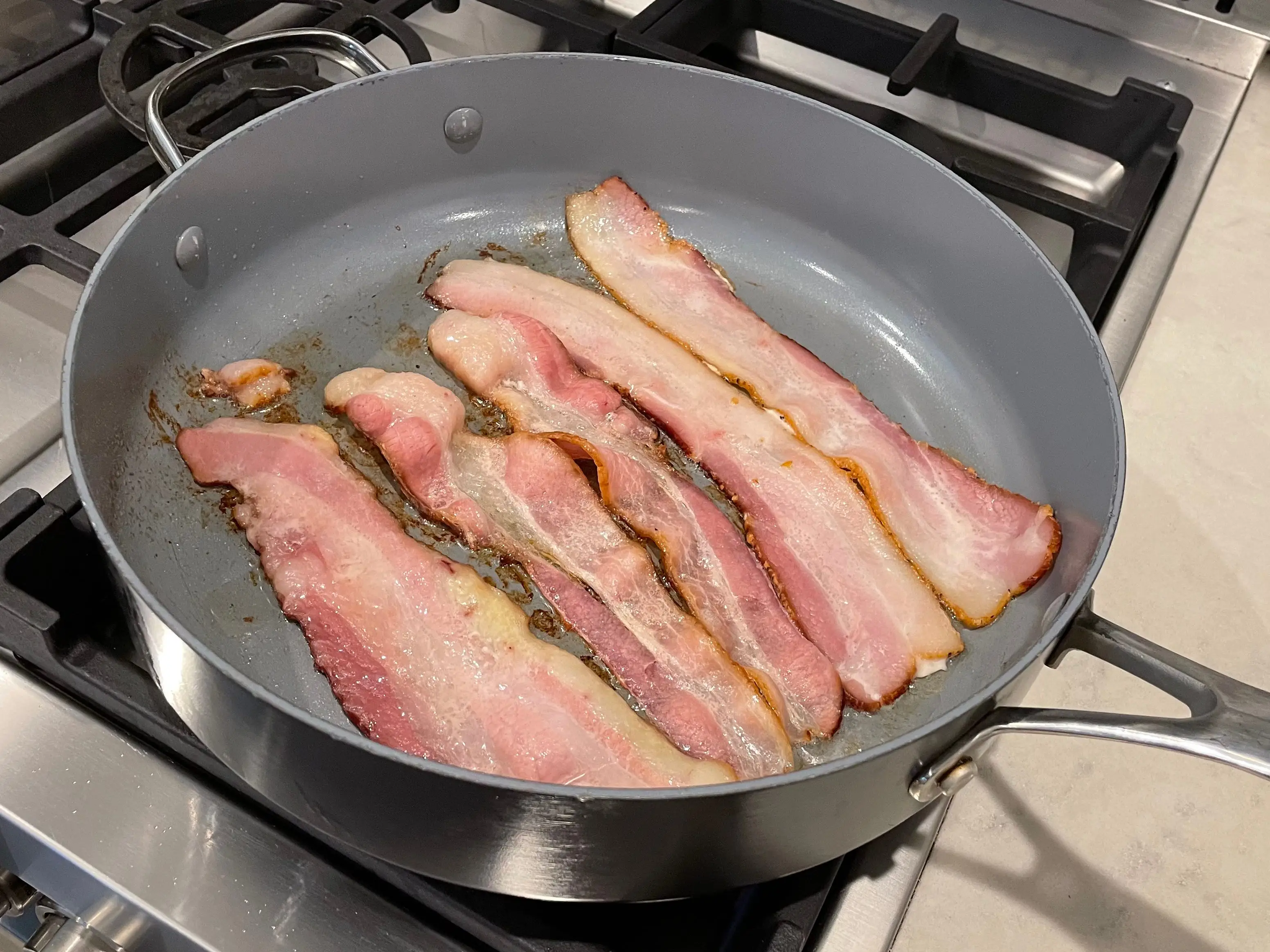 strips of cooked bacon in a frying pan