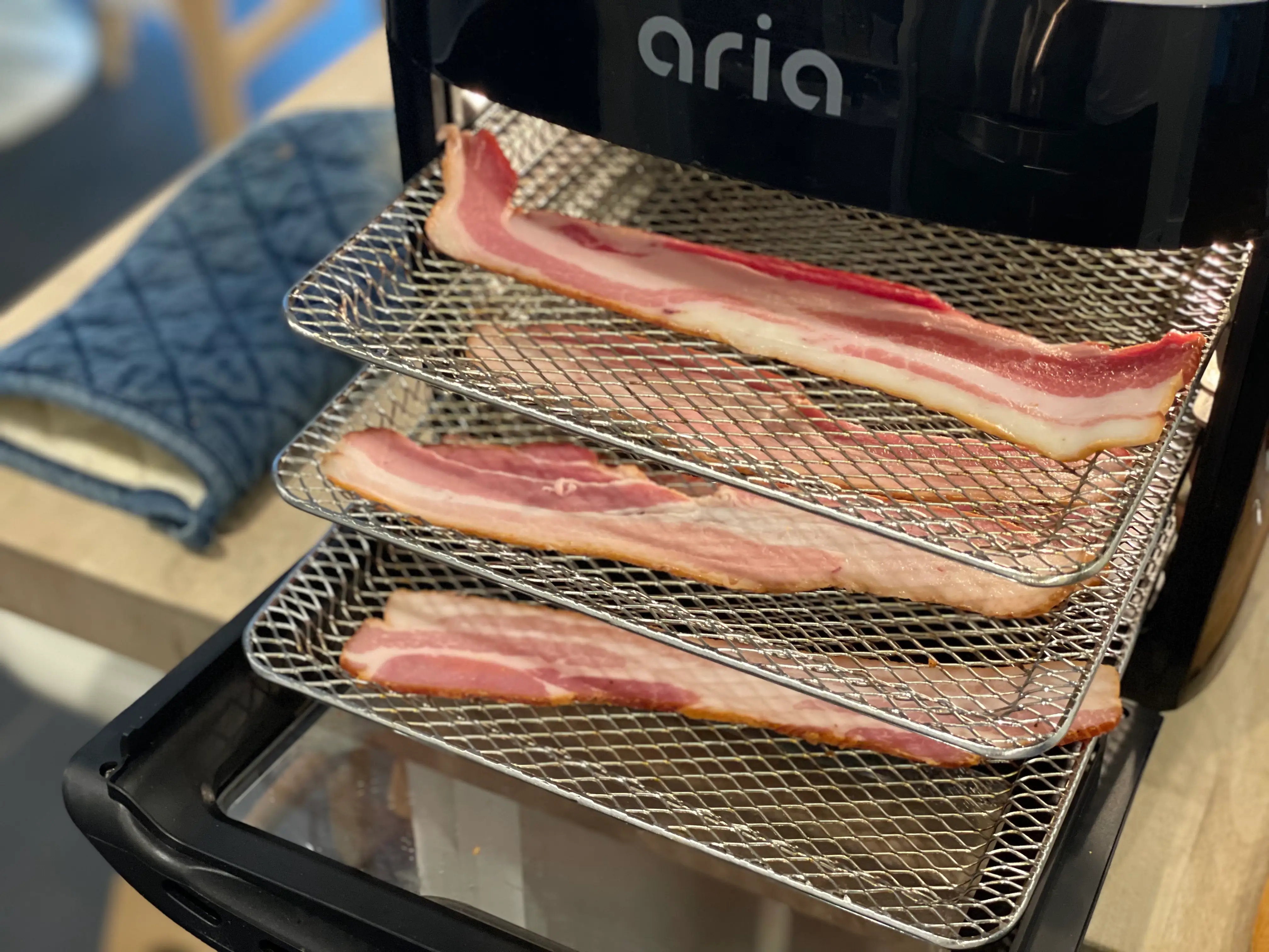 strips of bacon on rack inside an air fryer