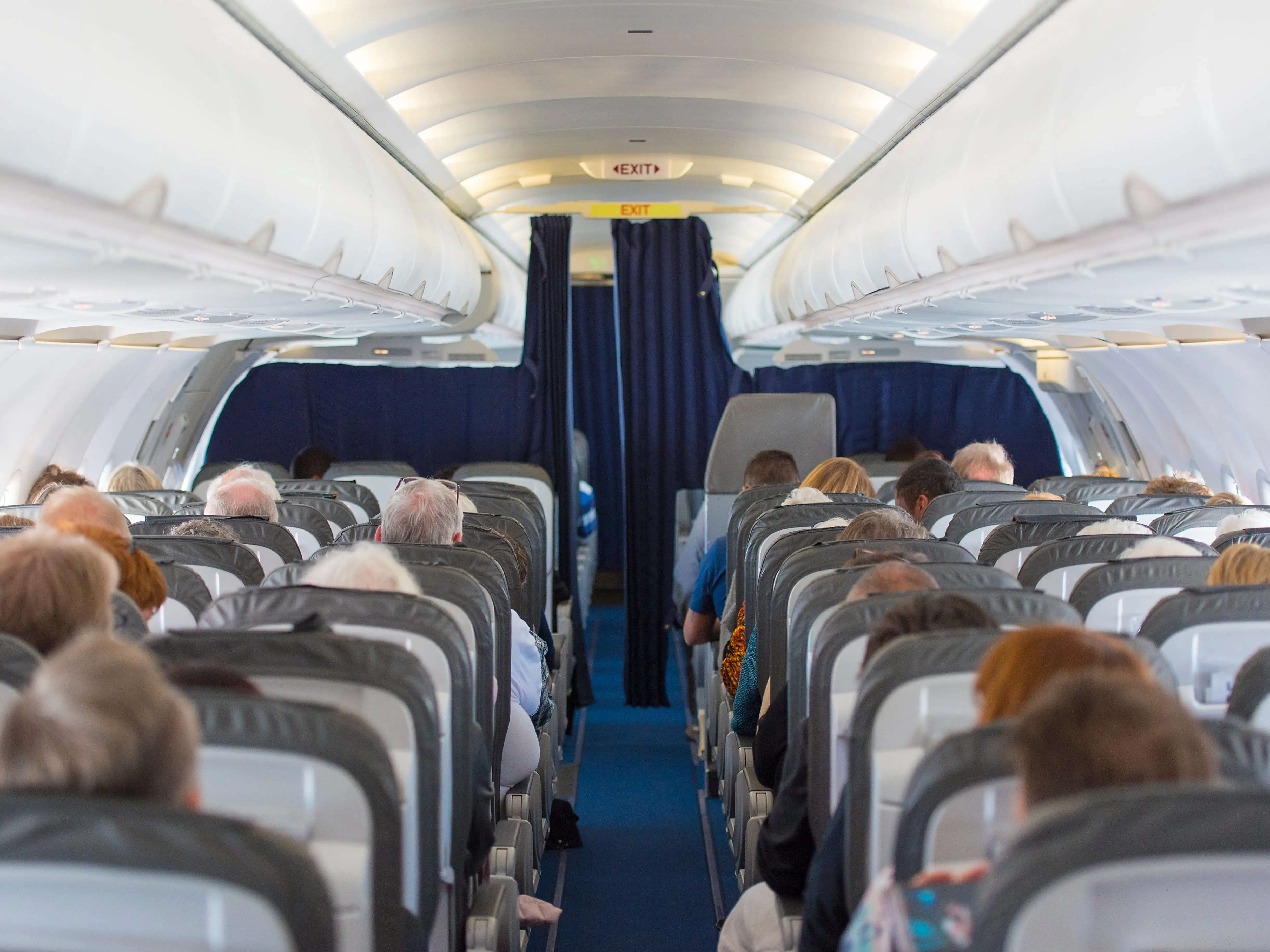 Commercial aircraft cabin filled with passengers in its seats.