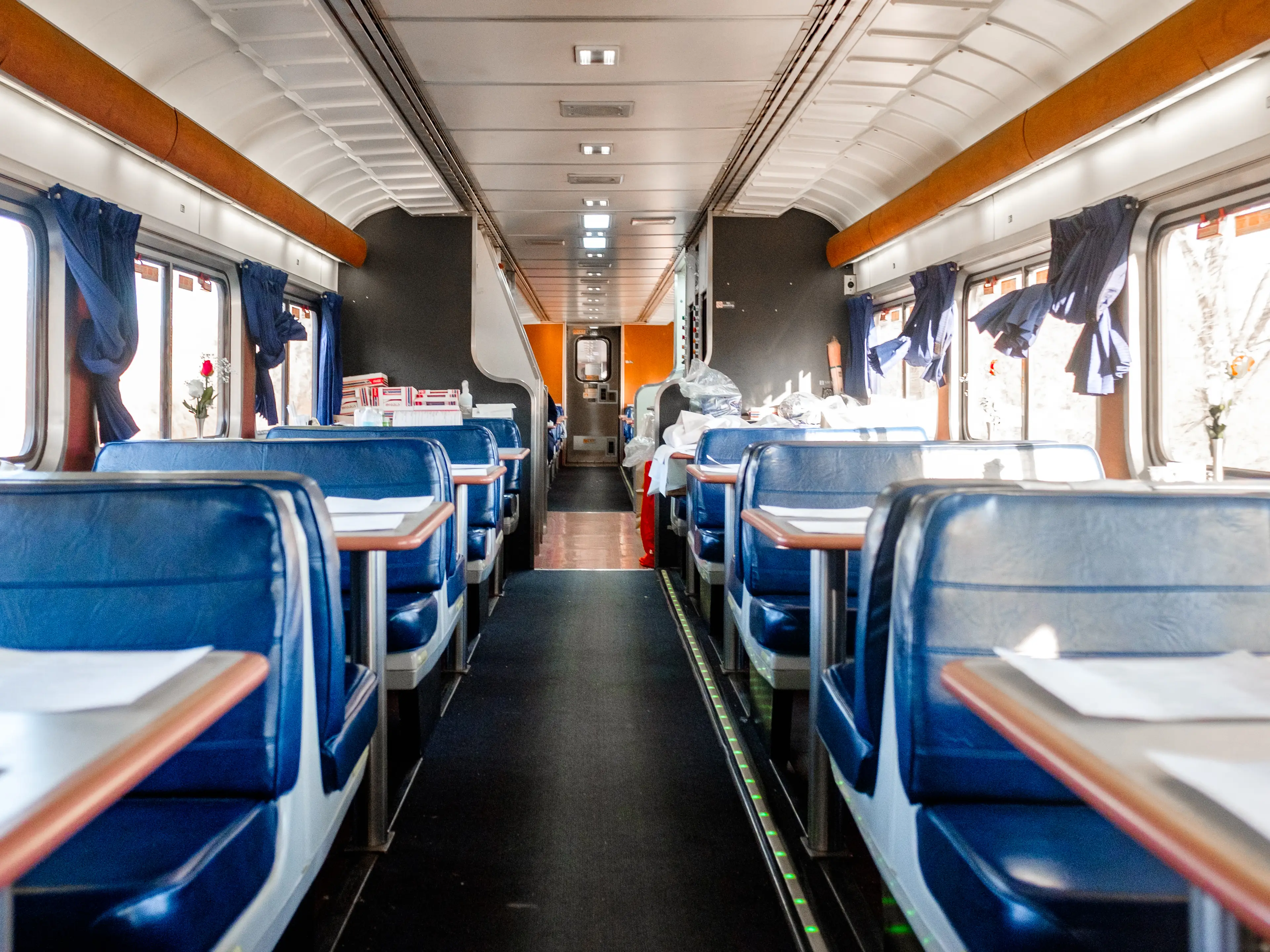 Inside an empty train dining car with blue booths