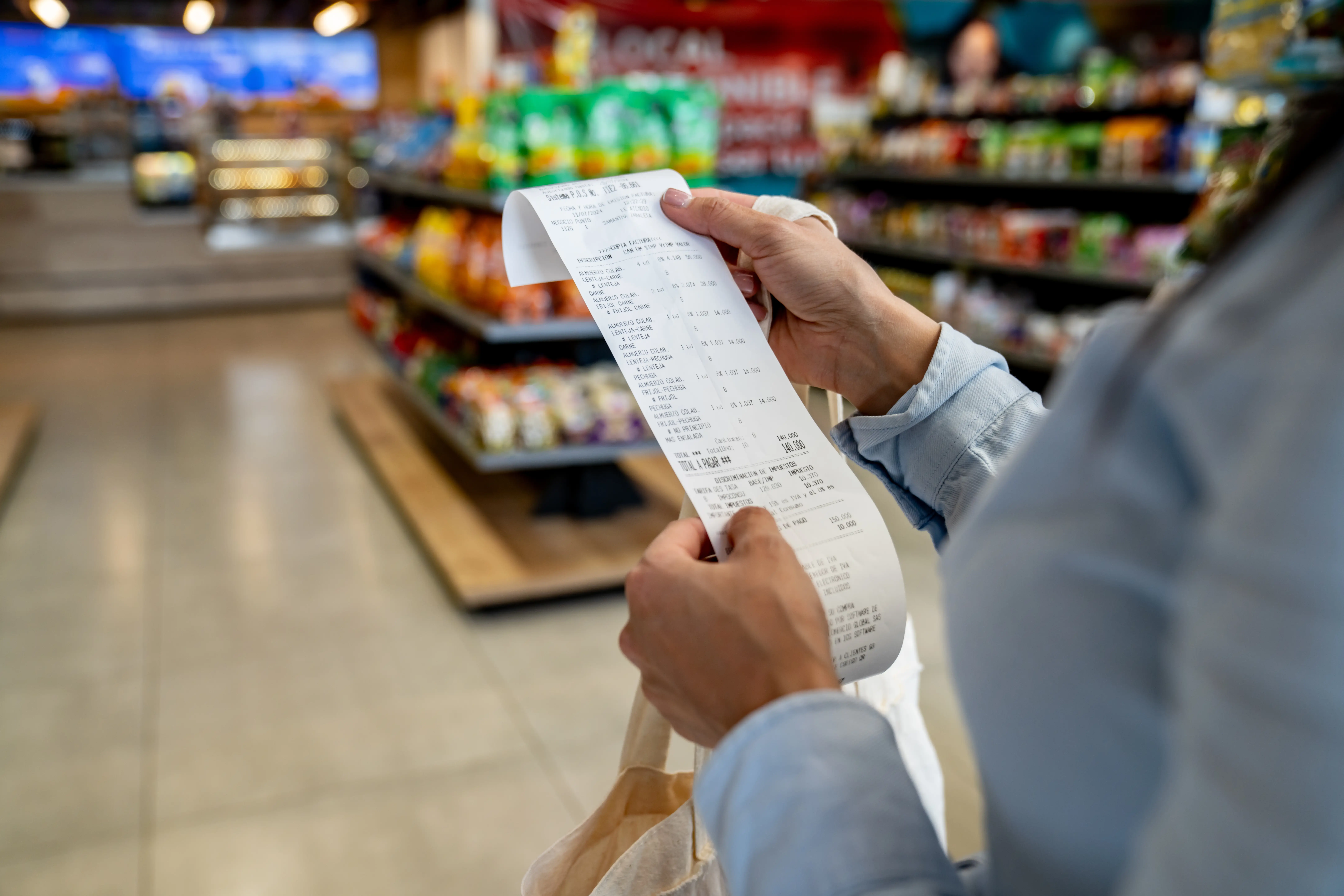 a person holding a grocery store reciept at the supermarket