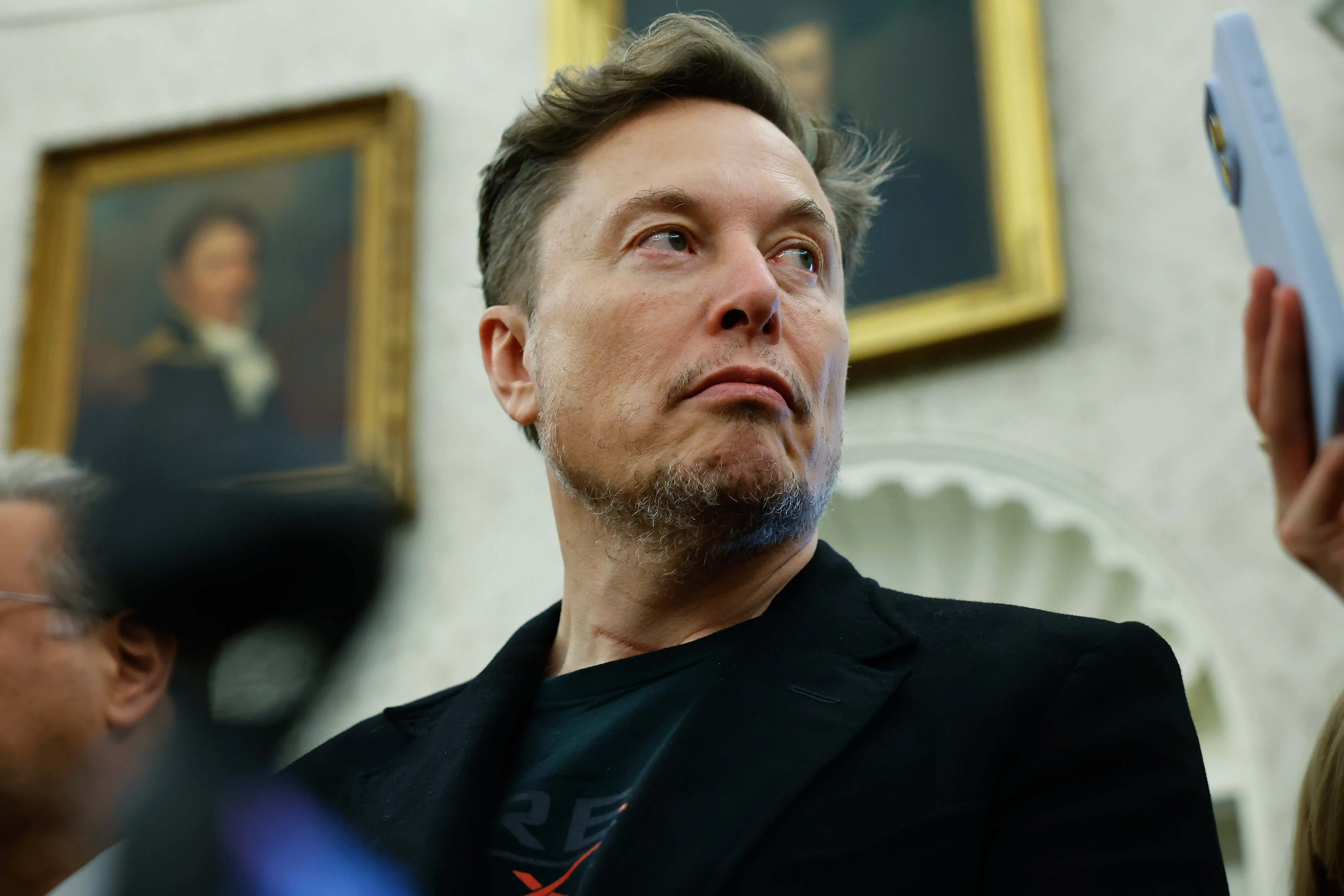 Elon Musk attending a press conference in the Oval Office at the White House.