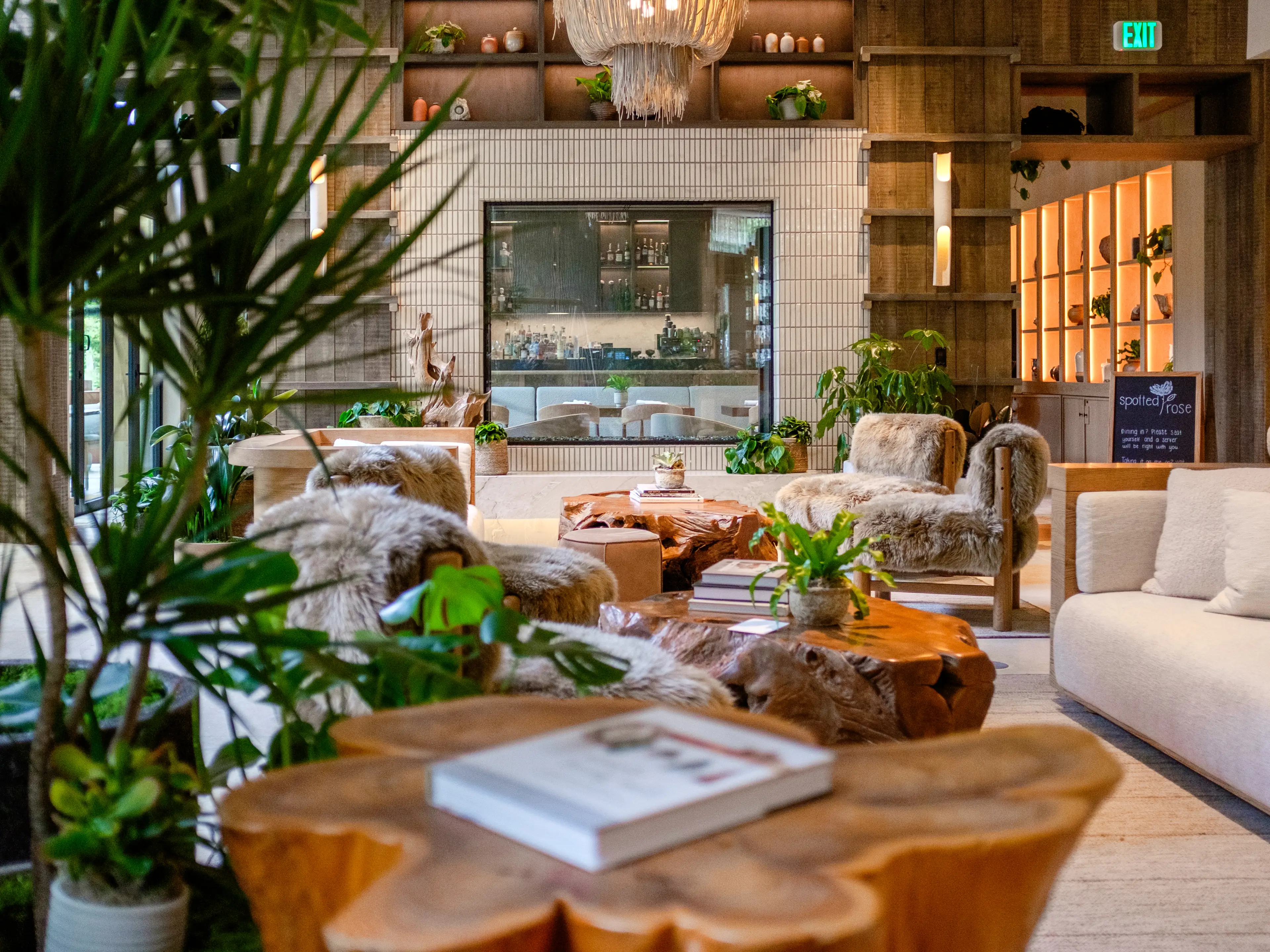 A hotel lobby full of plants and biophilic furniture