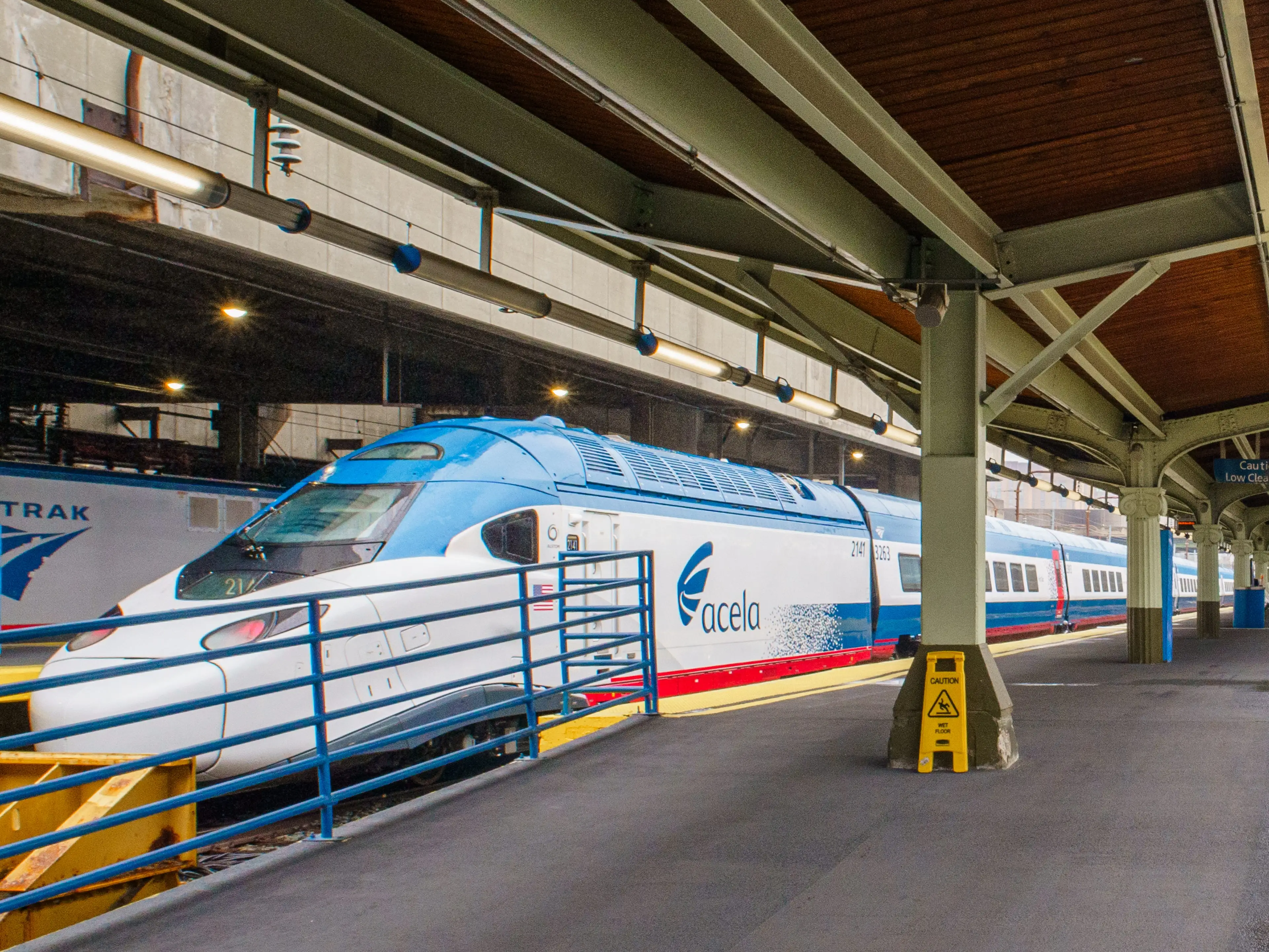 An Amtrak NextGen Acela train stopped at a covered platform