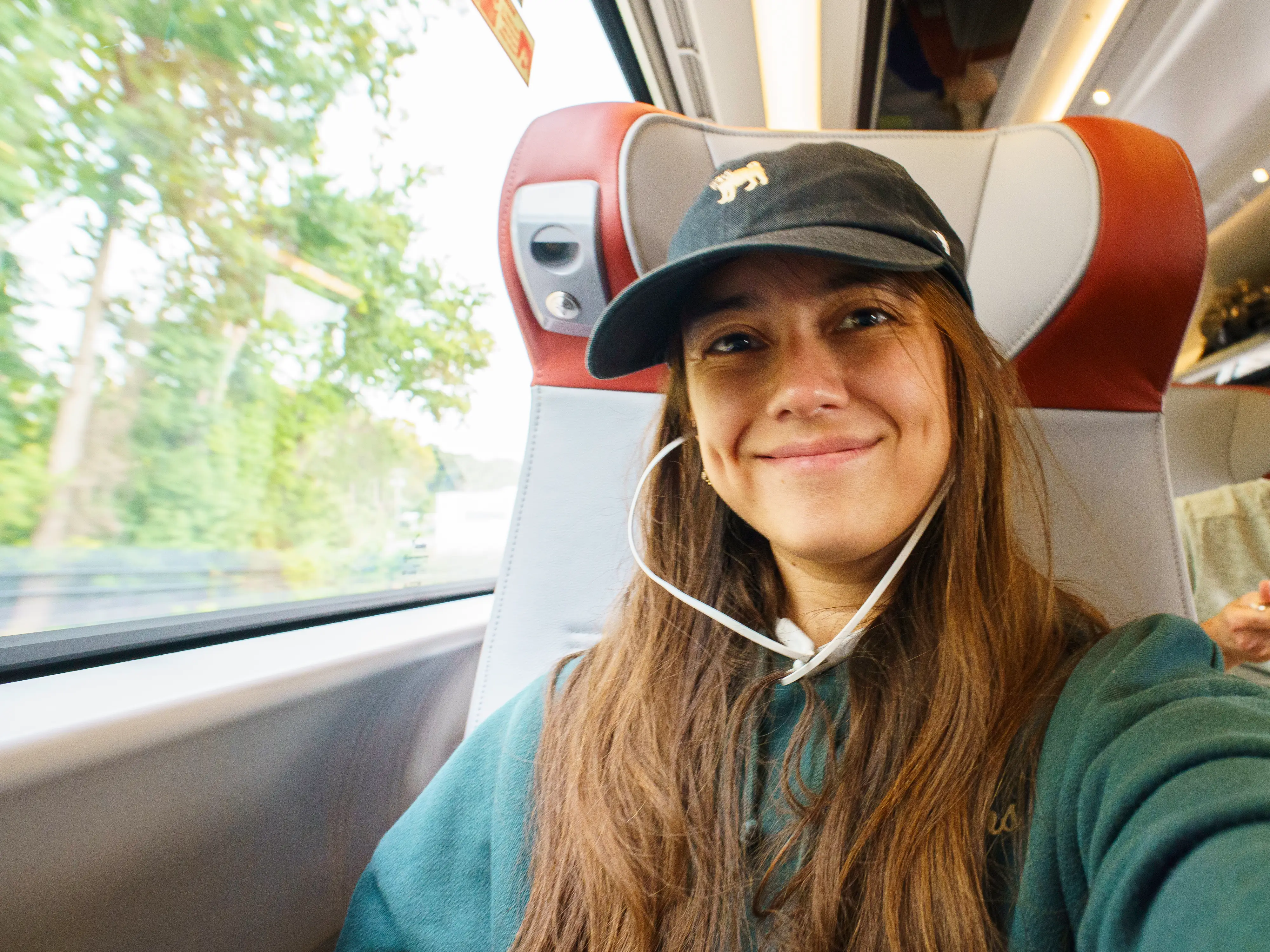 The author smiles in a first class window seat on a train