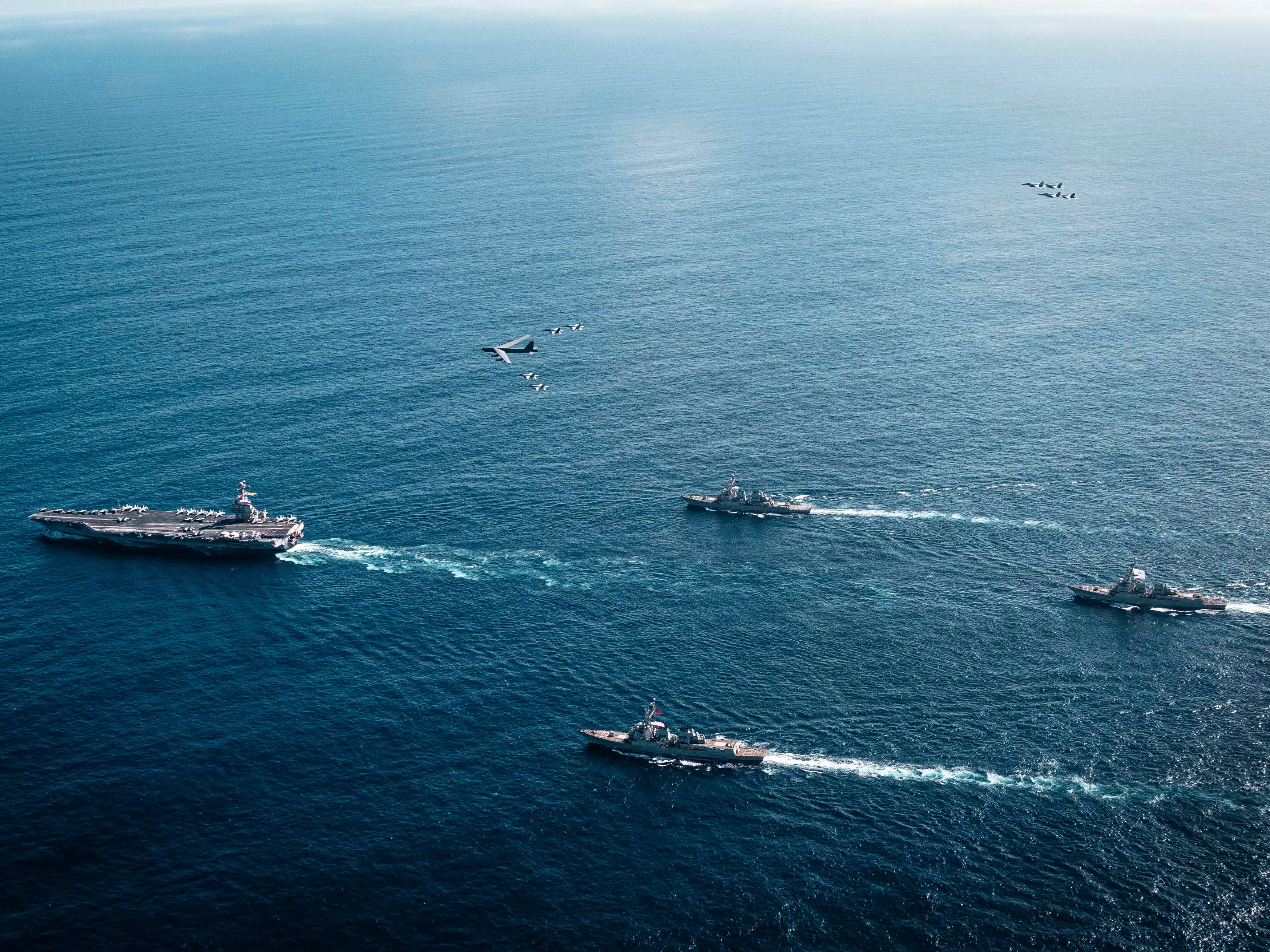 In this handout provided by the U.S. Navy, The U.S. Navy's Gerald R. Ford Carrier Strike Group, including the flagship USS Gerald R. Ford (CVN 78), left, USS Winston S. Churchill (DDG 81), front, USS Mahan (DDG 72), back, USS Bainbridge (DDG 96), and embarked Carrier Air Wing Eight F/A-18E/F Super Hornets assigned to Strike Fighter Squadrons 31, 37, 87, and 213, operates as a joint, multi-domain force with a U.S. Air Force B-52 Stratofortress, November 13, 2025. U.S. military forces, like the Gerald R. Ford Carrier Strike Group, are deployed in support of the U.S. Southern Command mission, Department of War-directed operations, and the President's priorities to disrupt illicit drug trafficking and protect the homeland.