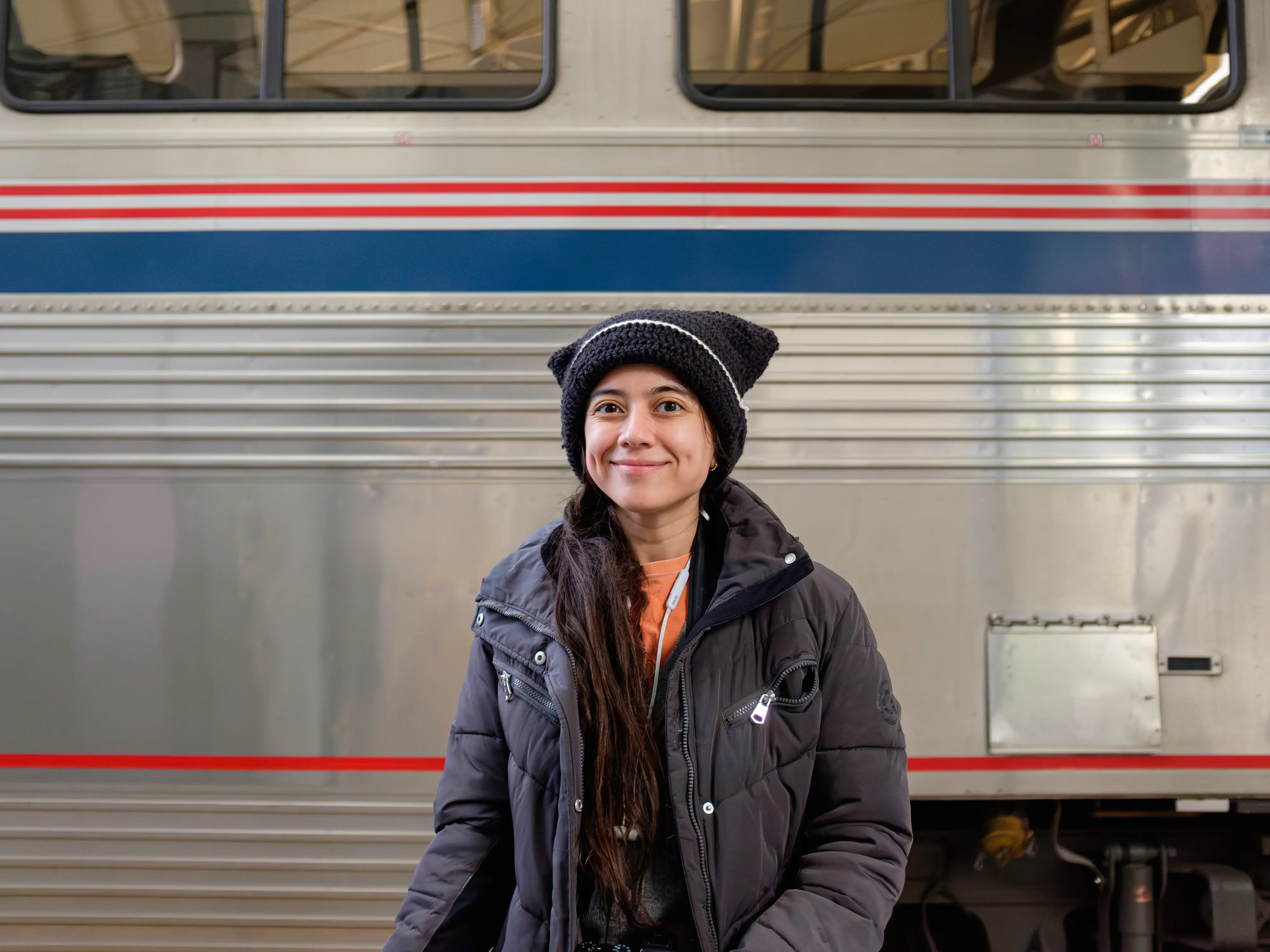 The author stands smiling in front of a train